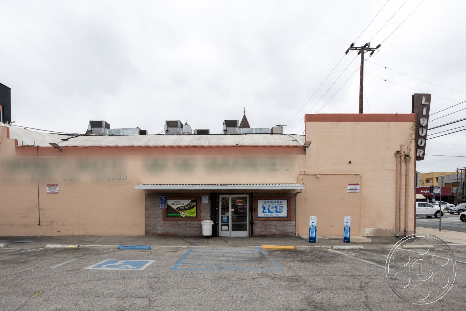 Shop 128 - exterior, urban setting, commercial building, asphalt parking lot, concrete sidewalk, stucco building facade, large glass storefront windows, flat roof with metal accents, brick base wall, signage with illuminated letters, handicapped parking space, overhead air conditioning units