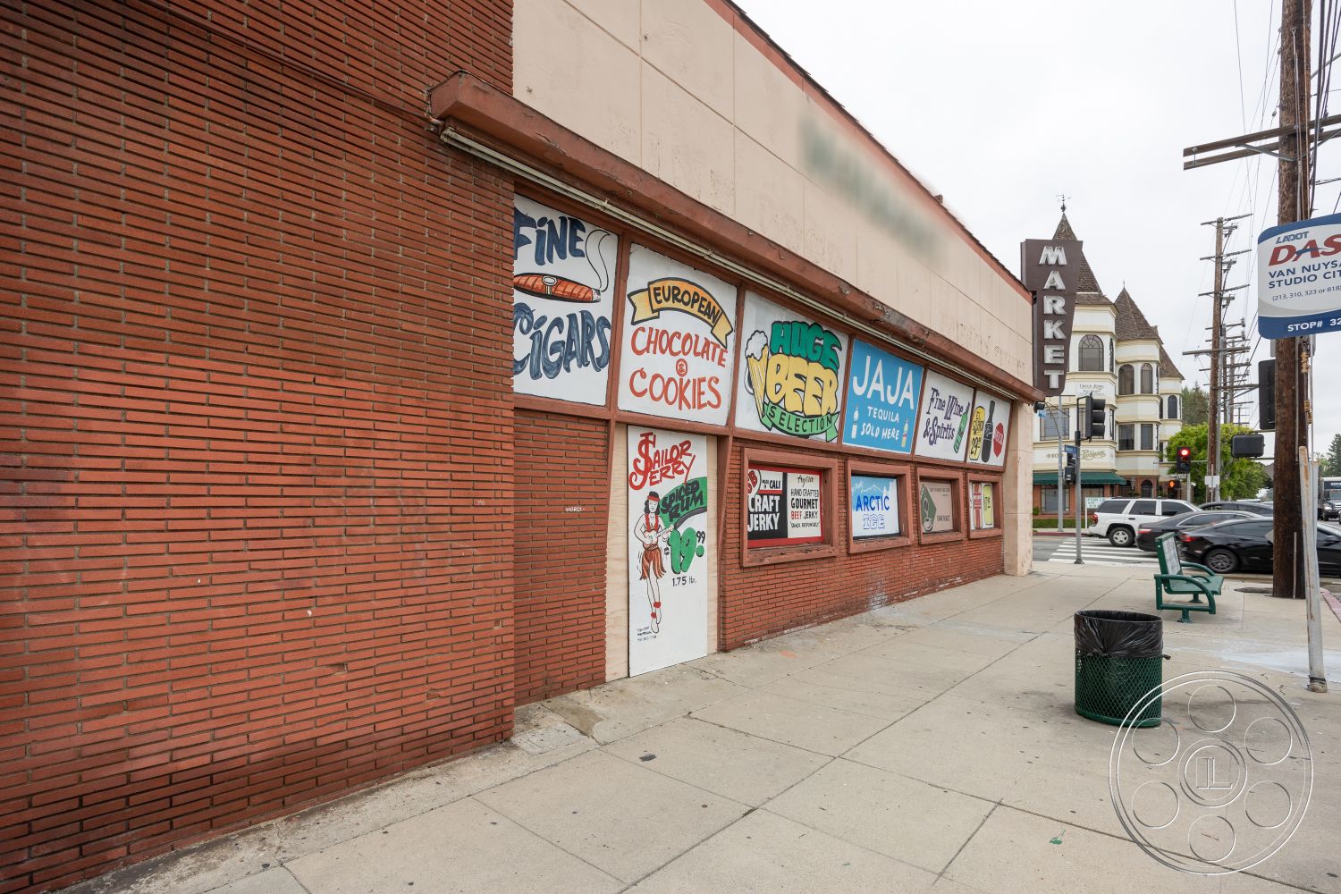 Shop 128 - exterior, red brick wall, large storefront windows, brick building facade, painted signage, commercial storefront, sidewalk area, metal trash receptacle, market signage, pedestrian street setting