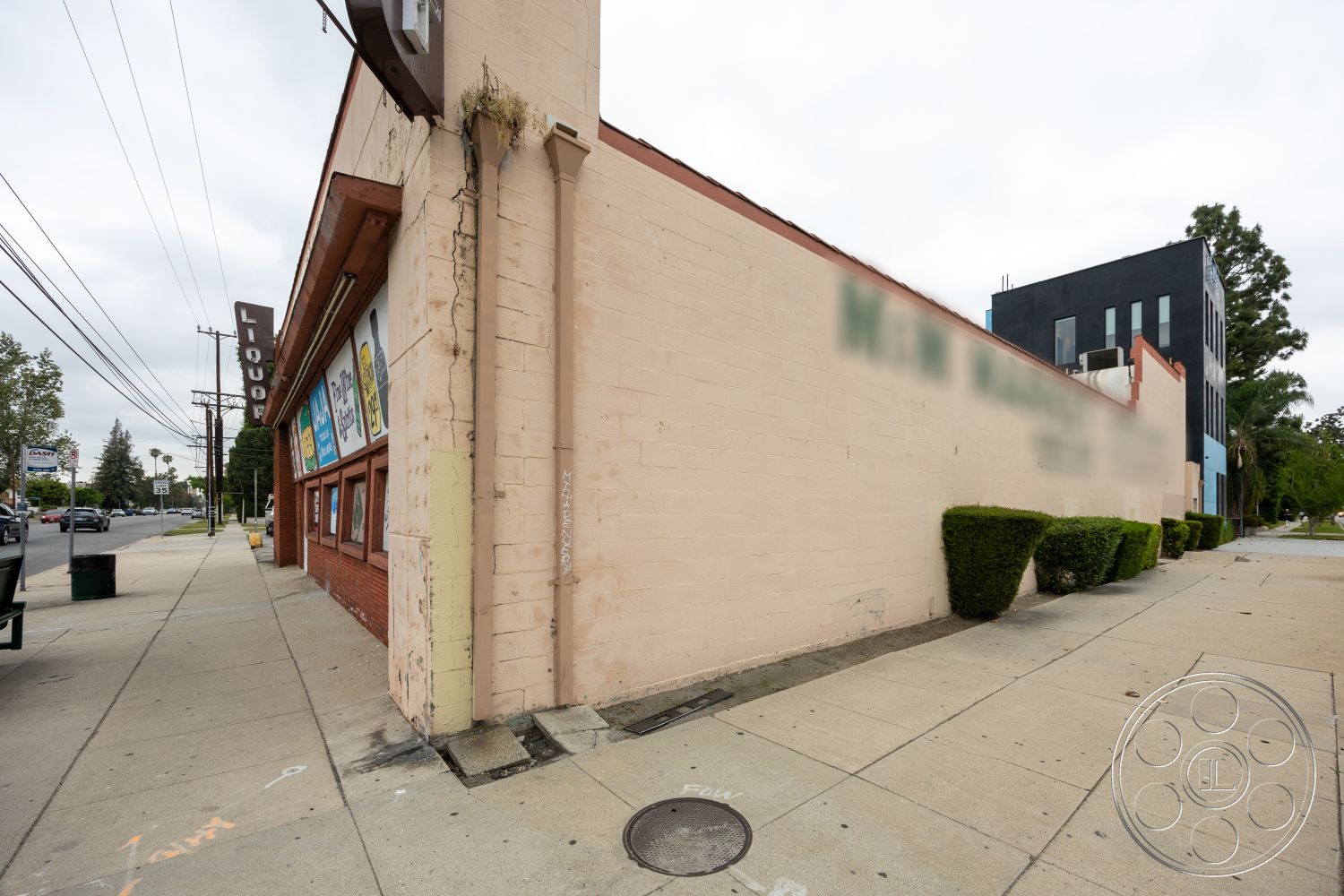 Shop 128 - exterior, flat roof, power lines, landscaped hedges, concrete sidewalk, stucco building facade, urban street setting, red brick foundation, commercial storefront windows, signage structure
