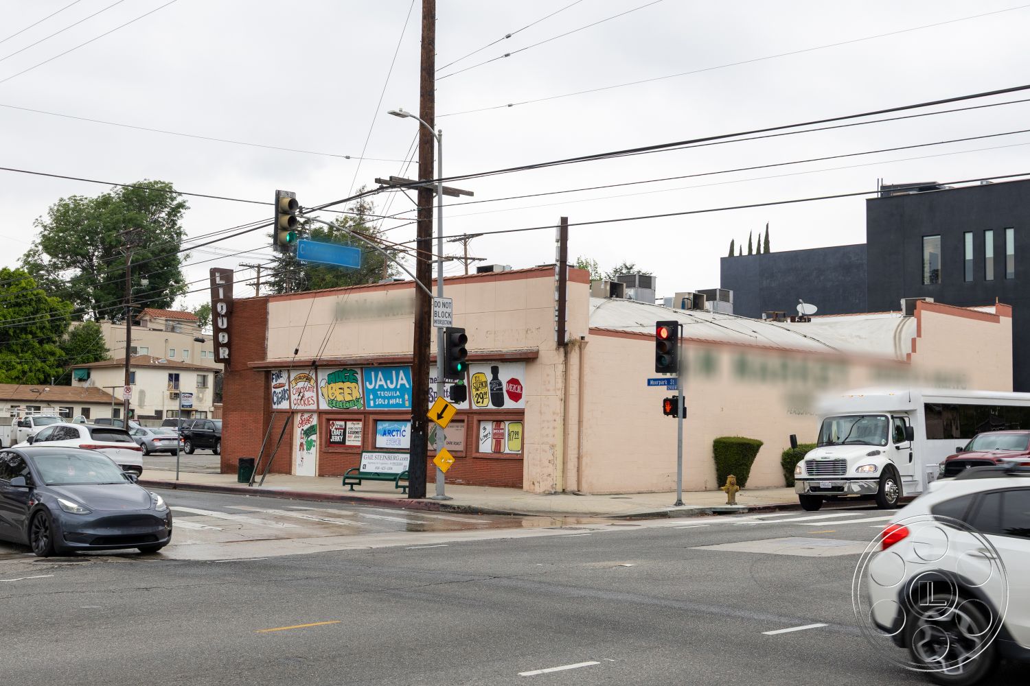 Shop 128 - exterior, flat roof, street lamps, paved parking lot, mixed-use urban setting, large display windows, brick wall facade, metal awning, painted stucco, neon signage, sidewalk curb, traffic signals