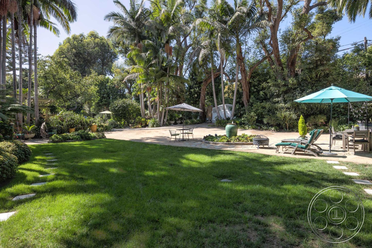 Americana 48 - exterior, palm trees, patio area, lush green lawn, lounge chairs, tropical landscaping, wooden outdoor furniture, garden planters, sunny outdoor setting, decorative stone border, flagstone stepping stones, beach umbrella, relaxed backyard atmosphere