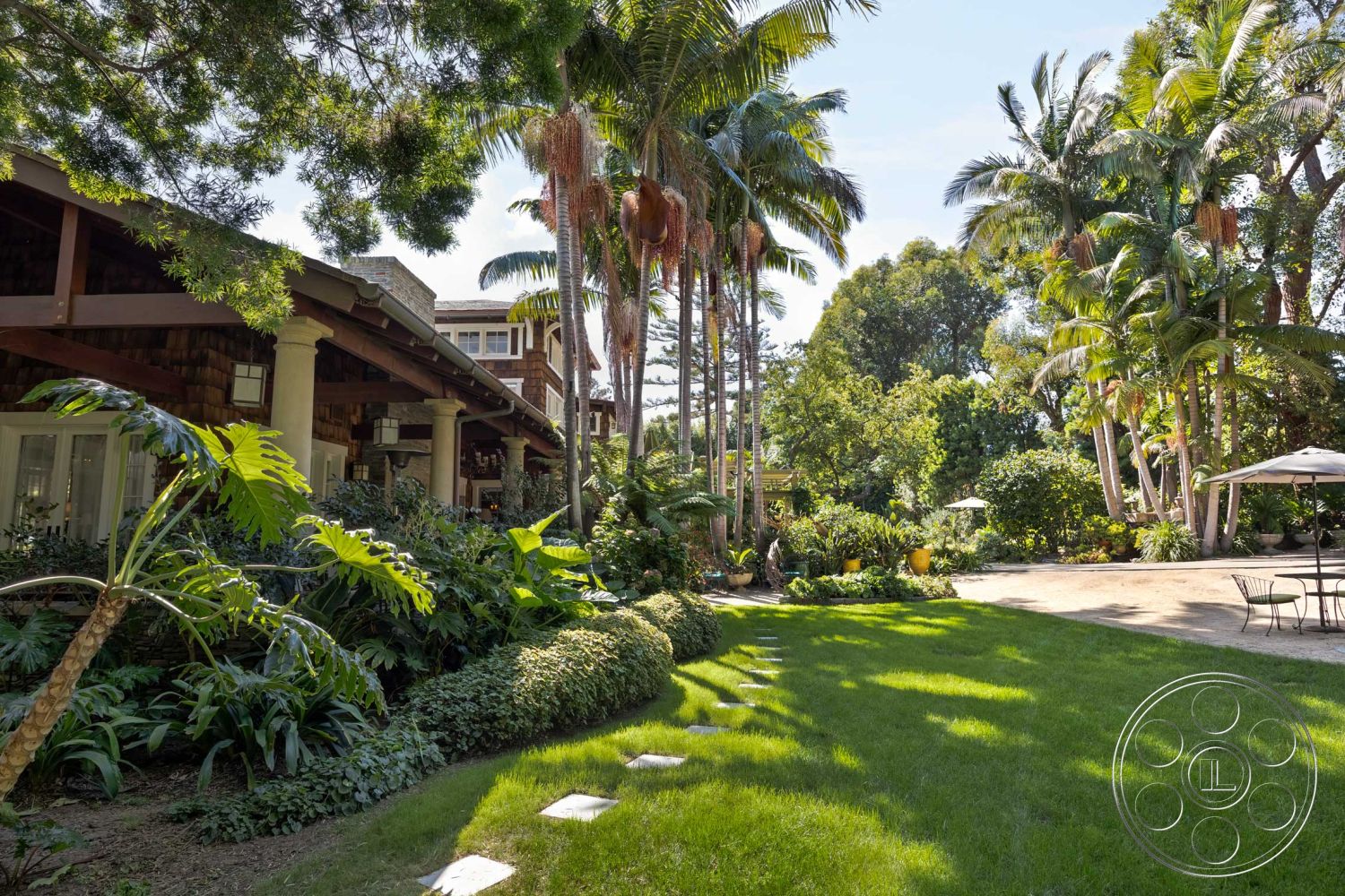 Americana 48 - palm trees, exposed beam ceiling, outdoor dining area, shingle siding, stone pathway, grassy lawn, lush tropical landscaping, metal patio furniture, residential exterior, sunny outdoor setting, garden with flowering plants, wooden porch structure