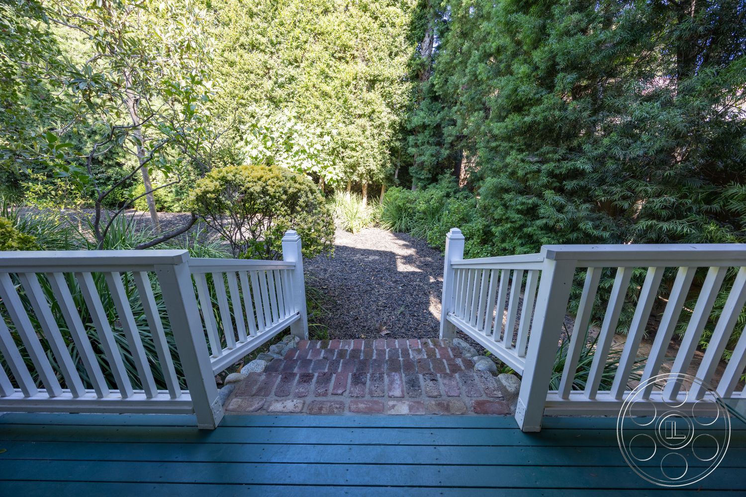 Americana 48 - exterior, lush greenery, stepping stones, brick pathway, white railing, garden setting, gravel path, landscape vegetation, wooden porch floor