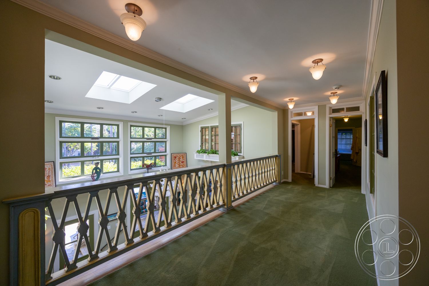 Americana 48 - recessed lighting, artwork on walls, floor-to-ceiling windows, vaulted ceiling, skylights, neutral painted walls, carpet hallway flooring, wood railing with decorative detailing, doorway arches