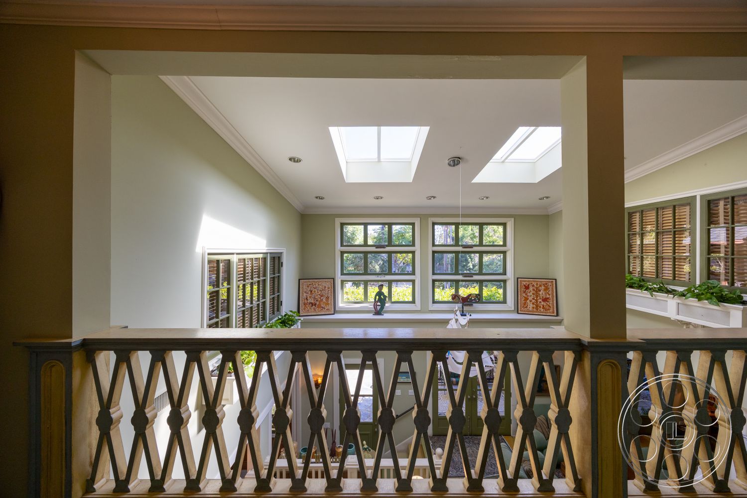 Americana 48 - natural lighting, plant decor, open floor plan, decorative wall art, window shutters, skylights, spacious hallway, coffered ceiling details, wooden balcony railing, green painted walls, multi-pane windows