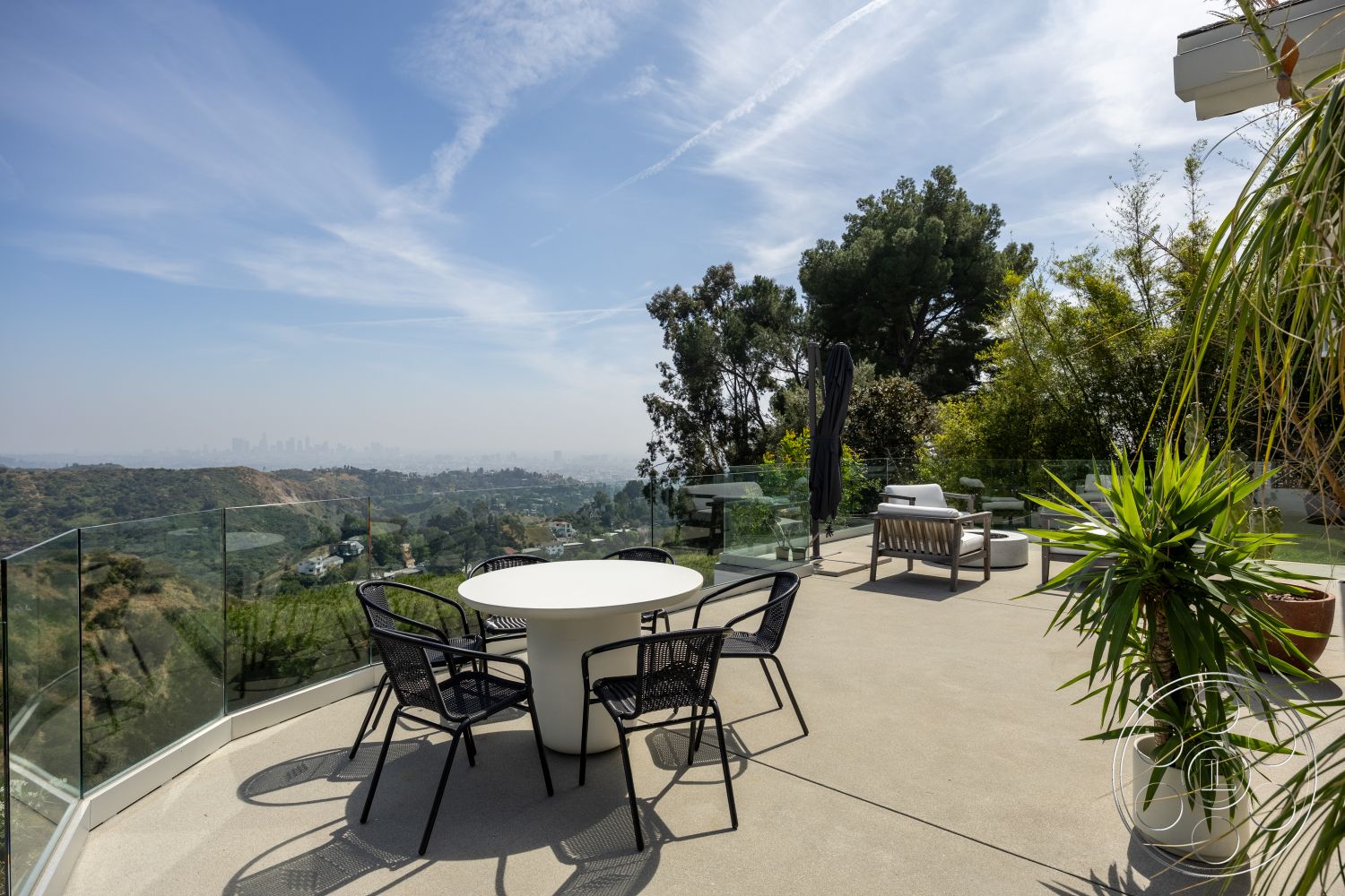 Retro 288 - exterior, glass railing, outdoor dining area, black metal chairs, outdoor lounge chairs, hillside location, concrete patio flooring, modern round dining table, landscaped garden with greenery, umbrella for shade, panoramic view of the city skyline, tropical plants in planters