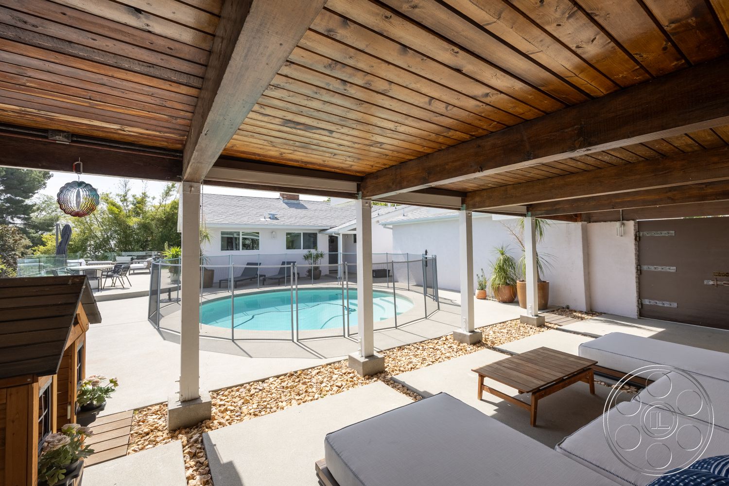 Retro 288 - exterior, outdoor seating area, rectangular pool, wooden outdoor furniture, landscaped garden area, modern home design, concrete patio flooring, wood beam ceiling, glass pool fencing, vaulted ceiling structure, accessory dwelling unit, poolside lounging space