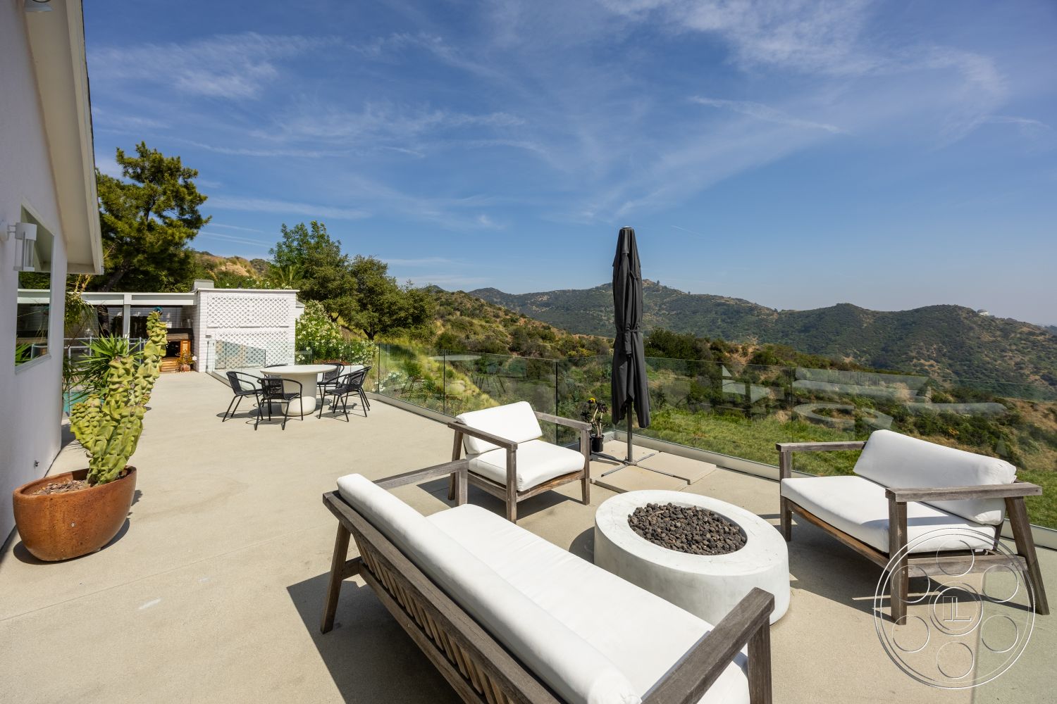 Retro 288 - exterior, glass railing, round dining table, mountain view, white upholstery, sunny outdoor area, concrete patio flooring, natural landscape setting, concrete fire pit, minimalist outdoor design, wooden patio chairs