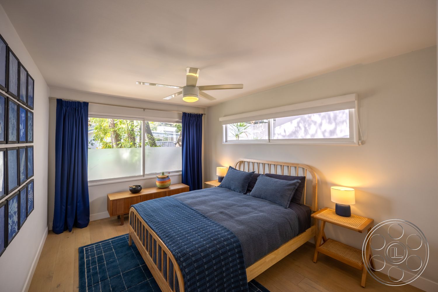 Retro 288 - glass windows, geometric area rug, wooden bed frame, cotton bedding, recessed ceiling lights, hardwood bedroom floors, white painted walls, contemporary bedside lamps, modern artwork display, blue curtain drapes