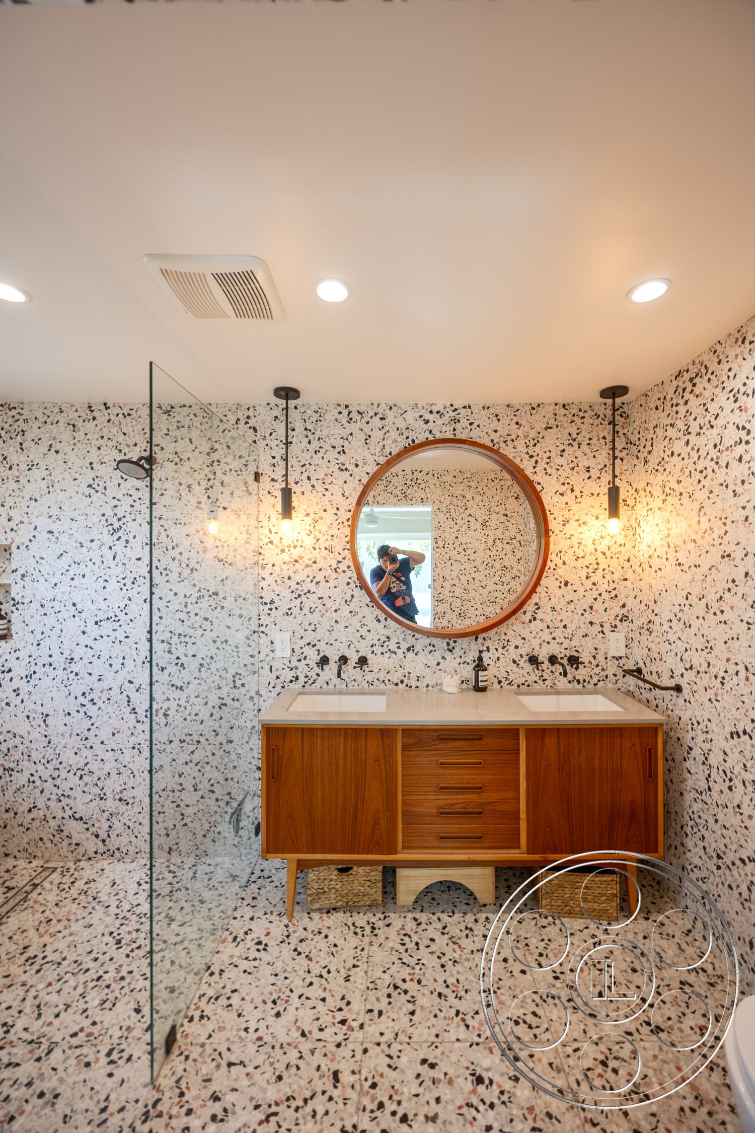 Retro 288 - glass shower enclosure, modern pendant lighting, textured ceiling, contemporary bathroom design, terrazzo bathroom flooring, wood vanity cabinet, bright and airy interior, terrazzo shower walls, double sink bathroom countertop, round mirror with wooden frame