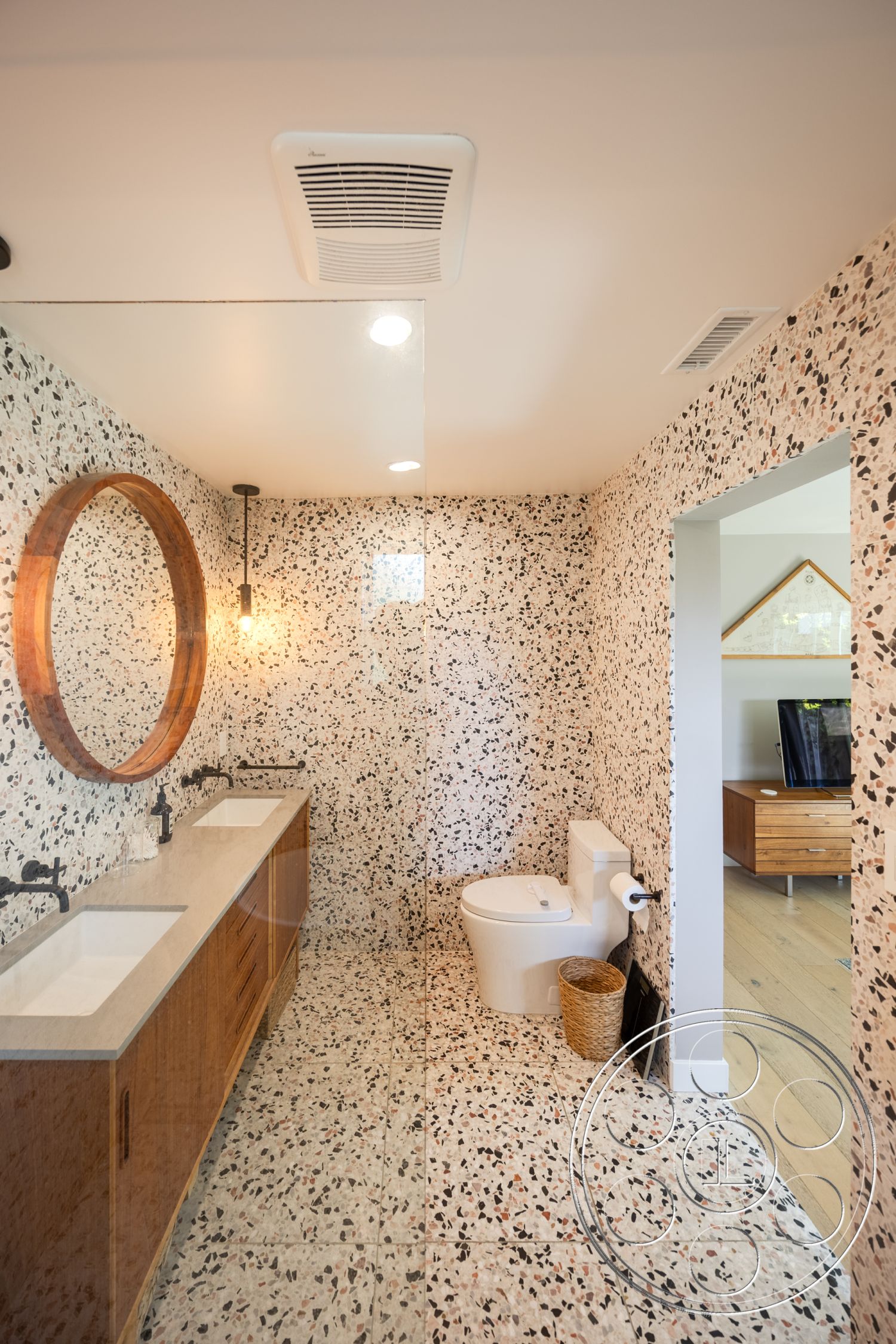 Retro 288 - terrazzo flooring, round mirror, pendant lighting, interior bathroom, glass shower partition, light wood plank flooring, black faucet fixtures, terrazzo wall treatment, wood vanity cabinets, double sink bathroom, toilet with modern design, woven basket storage
