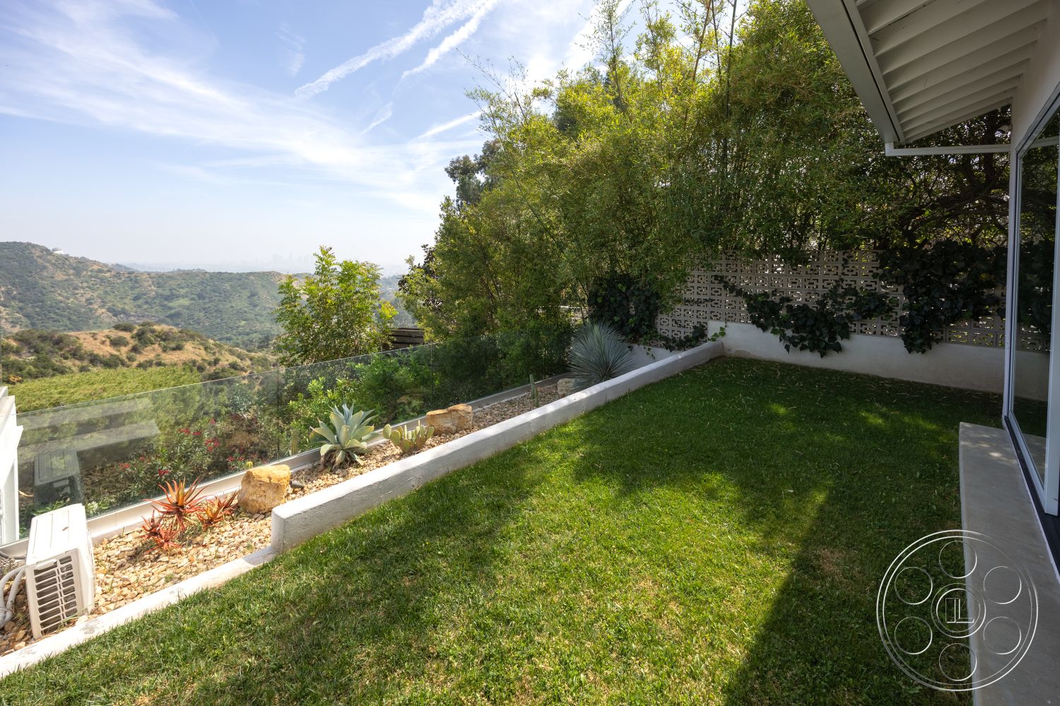 Retro 288 - exterior, glass railing, bamboo plants, grass lawn, outdoor living space, hillside view, mountain backdrop, paving stones, stone garden border, decorative concrete wall, landscape with succulents