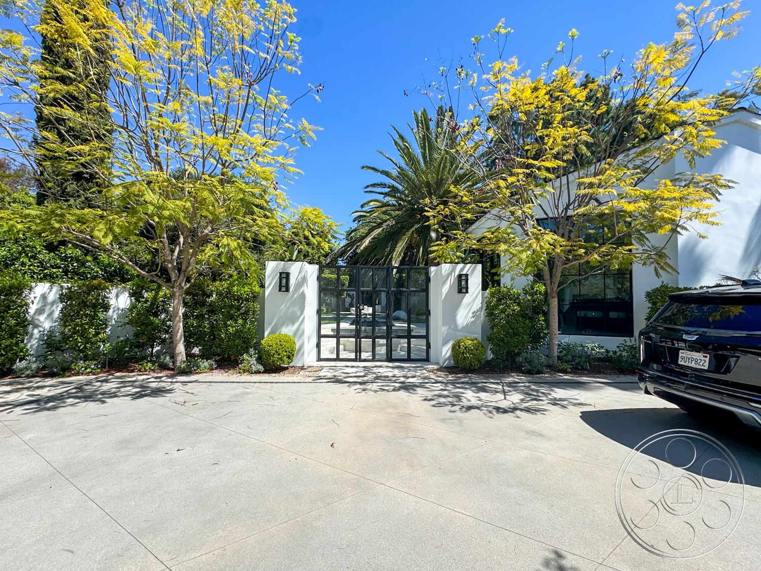 Modern 522 - large windows, exterior, landscaped garden, concrete driveway, tropical palm trees, ornamental shrubs, stucco exterior walls, minimalist architectural style, modern glass entry doors, natural stone garden border