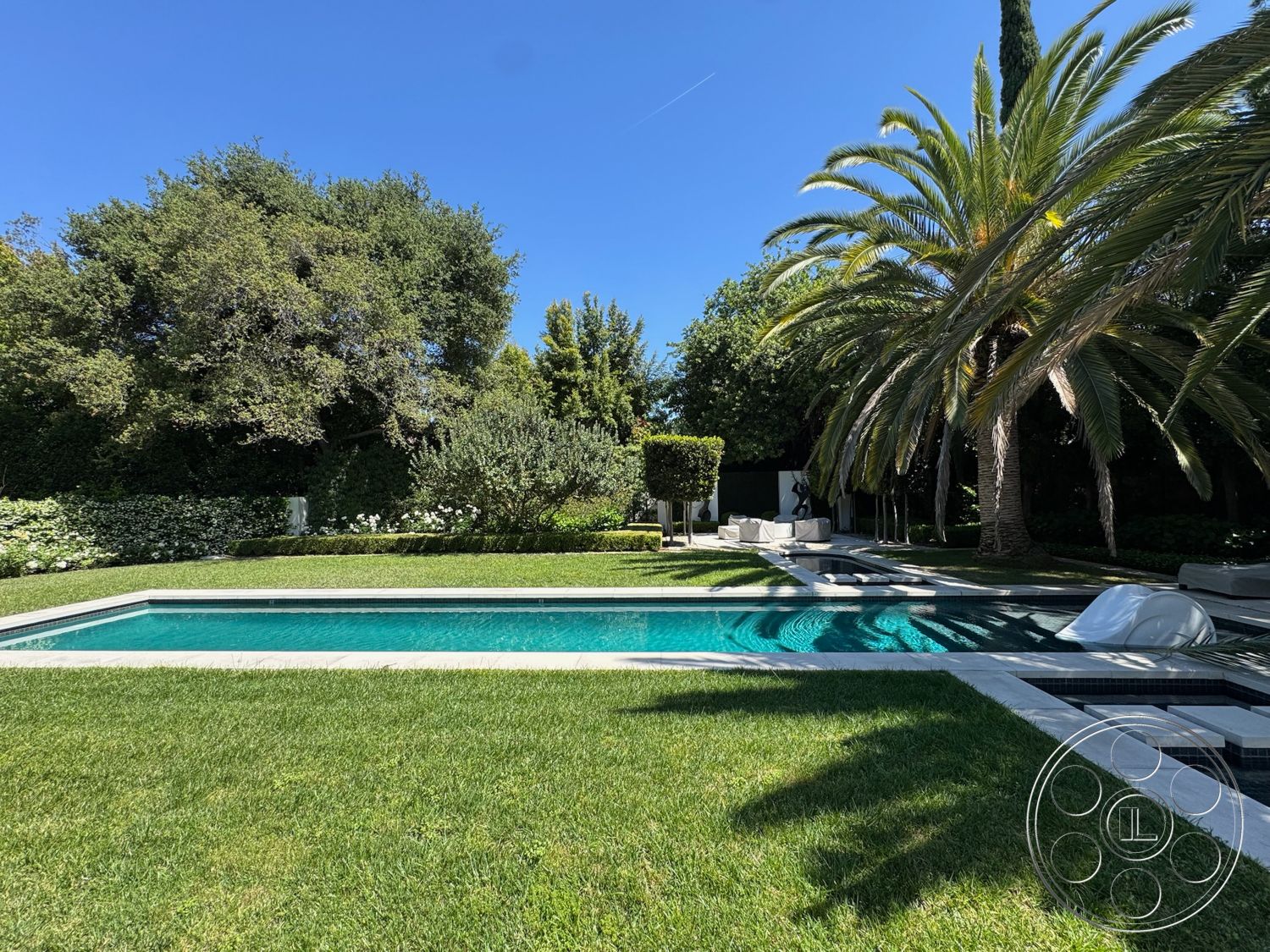 Modern 522 - exterior, patio area, grass lawn, sun loungers, fountain feature, tropical palm trees, rectangular pool, greenery backdrop, swimming pool area, sunny outdoor setting, hedge border, landscaped garden beds, concrete pool border, outdoor leisure space