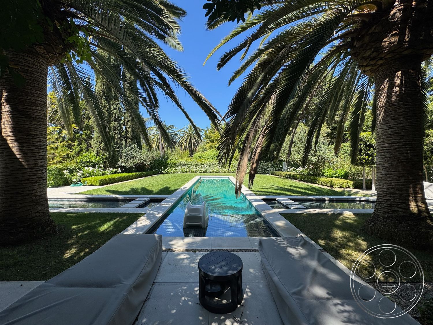 Modern 522 - exterior, palm trees, concrete patio, rectangular swimming pool, stone pathway, green lawn, sunny outdoor setting, modern outdoor seating area, lush garden landscaping, tile pool deck, luxury lounge chairs