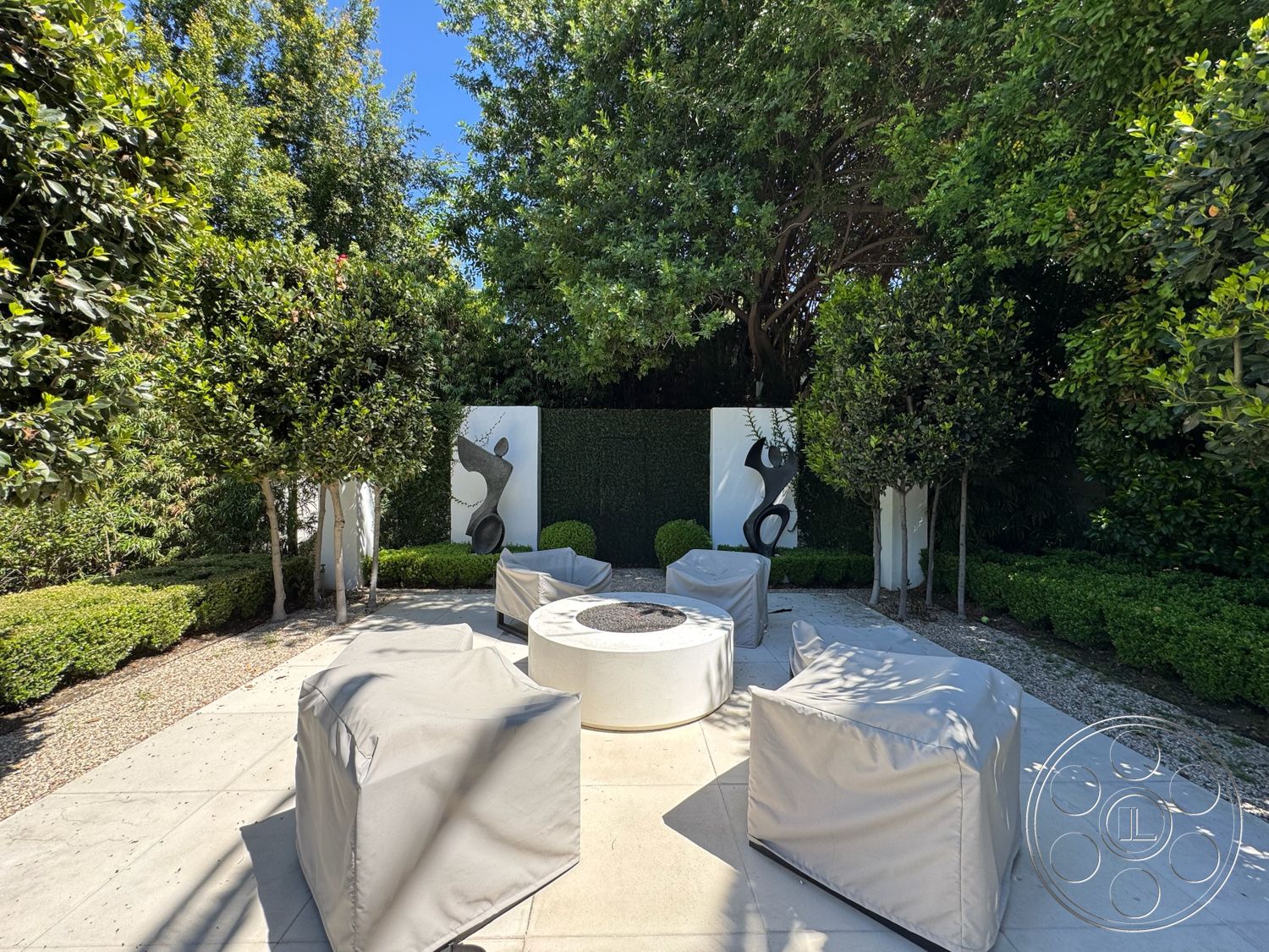 Modern 522 - exterior, landscaped garden, decorative wall art, planted greenery, gravel landscaping, ambient outdoor lighting, boxwood hedges, hedge privacy wall, circular fire pit, upholstered outdoor furniture, concrete patio floor