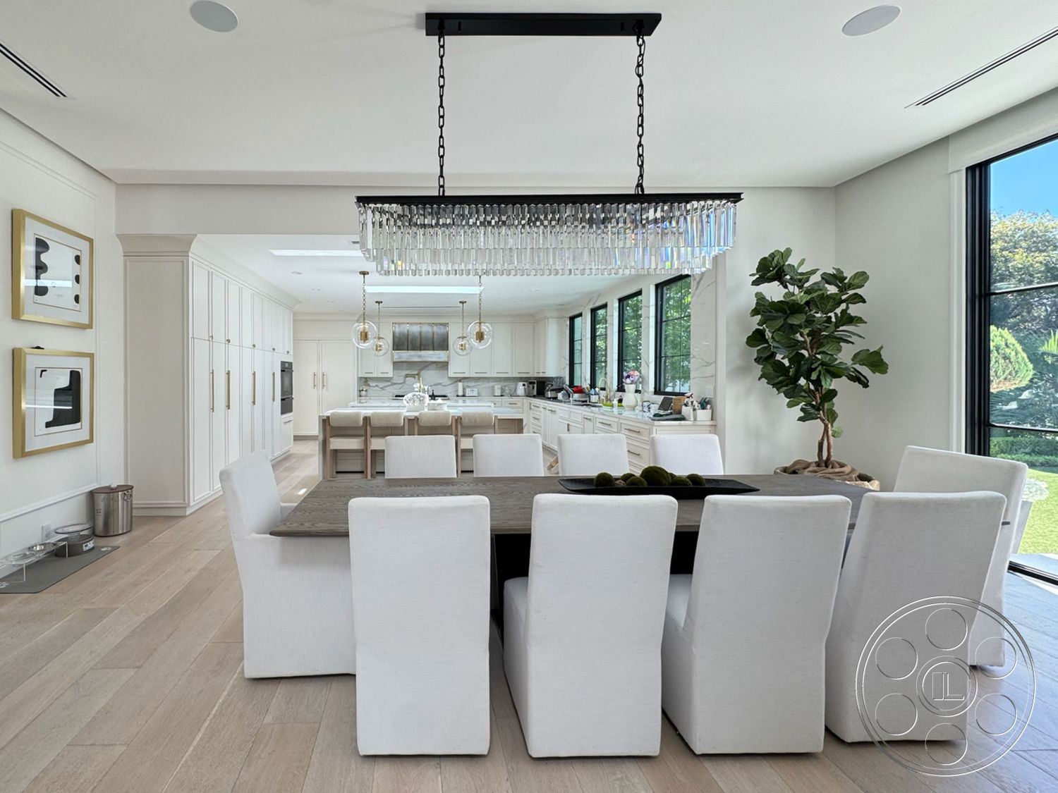 Modern 522 - neutral color palette, contemporary design elements, decorative indoor plant, open kitchen layout, minimalist wall art, chandelier with crystal accents, exposed ceiling with recessed lighting, black steel window frames, white cabinetry with gold hardware, smooth white plaster walls, white upholstered dining chairs, light hardwood dining room floors, modern rectangular dining table, glass sliding windows