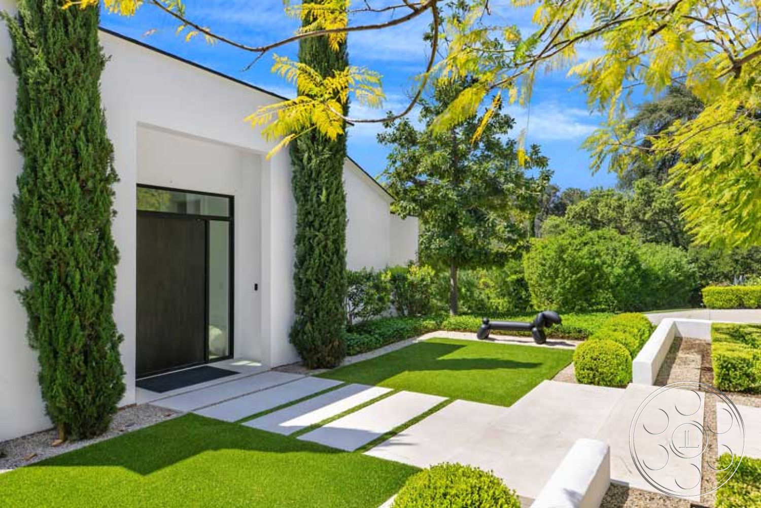 Modern 522 - exterior, modern architecture, flat roof, landscaped yard, concrete pathway, floor-to-ceiling windows, black sculpture, garden area, topiary shrubs, cedar trees, white painted walls, synthetic lawn, geometric landscape design, minimalist front entrance, light granite pavers