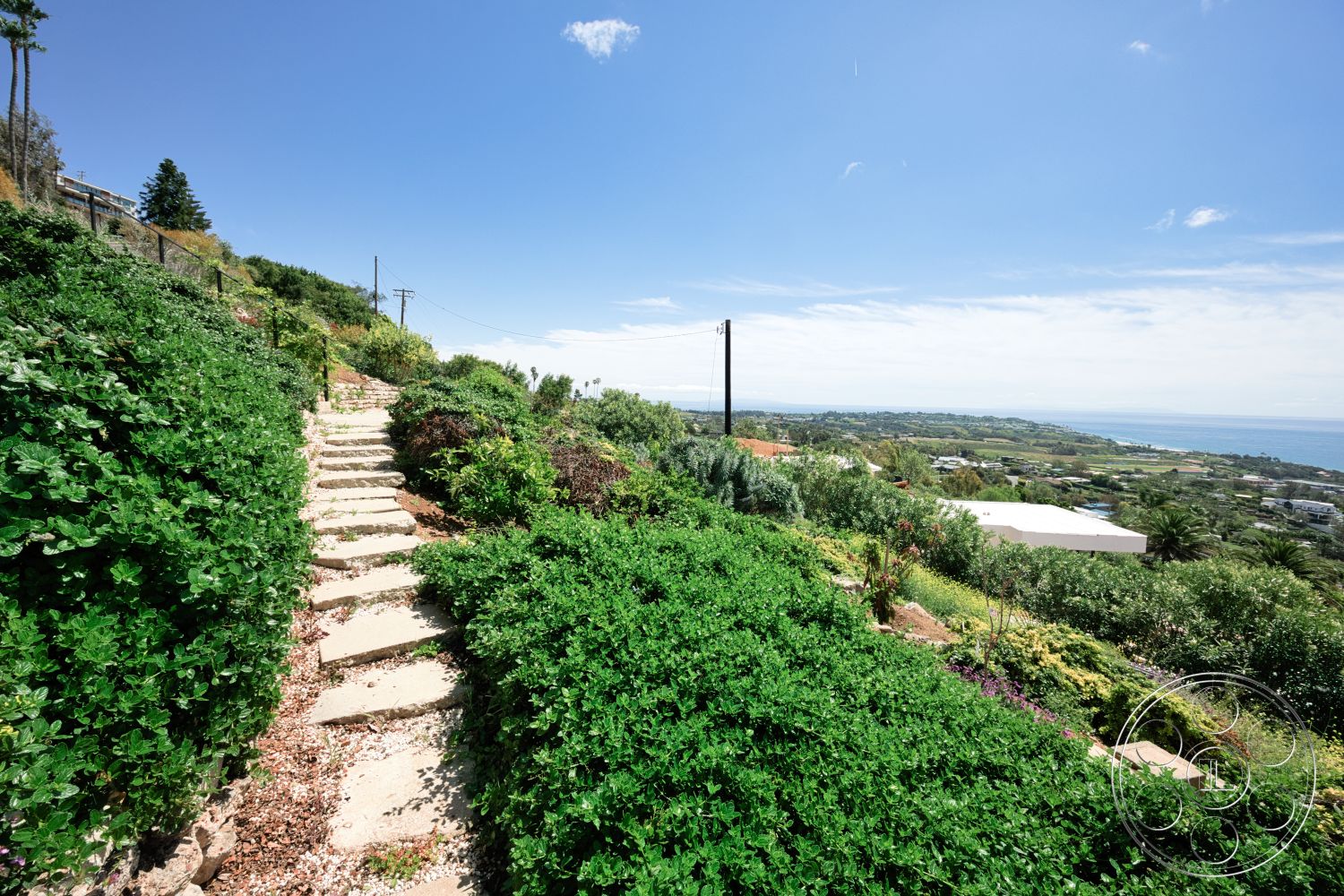 Modern 523 - exterior, ocean view, natural stone steps, hillside location, mixed shrubbery, lush green foliage, sunny weather, landscaped garden pathway, rocky gravel pathway, scenic overlooks