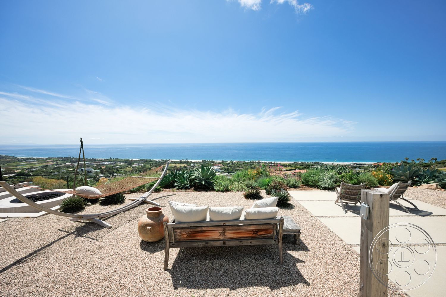 Modern 523 - exterior, desert landscaping, spacious outdoor area, wooden lounge chairs, hammock, gravel patio flooring, oceanfront view, natural stone planter, wooden outdoor bench, succulent plant arrangements, sunny coastal environment, concrete patio squares