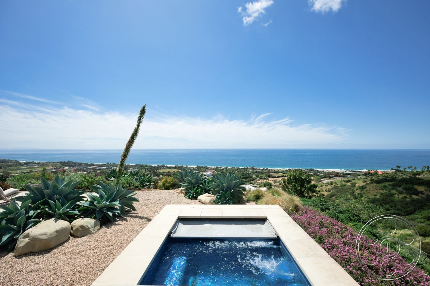 Modern 523 - exterior, landscaped garden, ocean view, infinity pool, sunny coastal setting, succulent plants, mountainous backdrop, tropical vegetation, stone pool deck, gravel patio