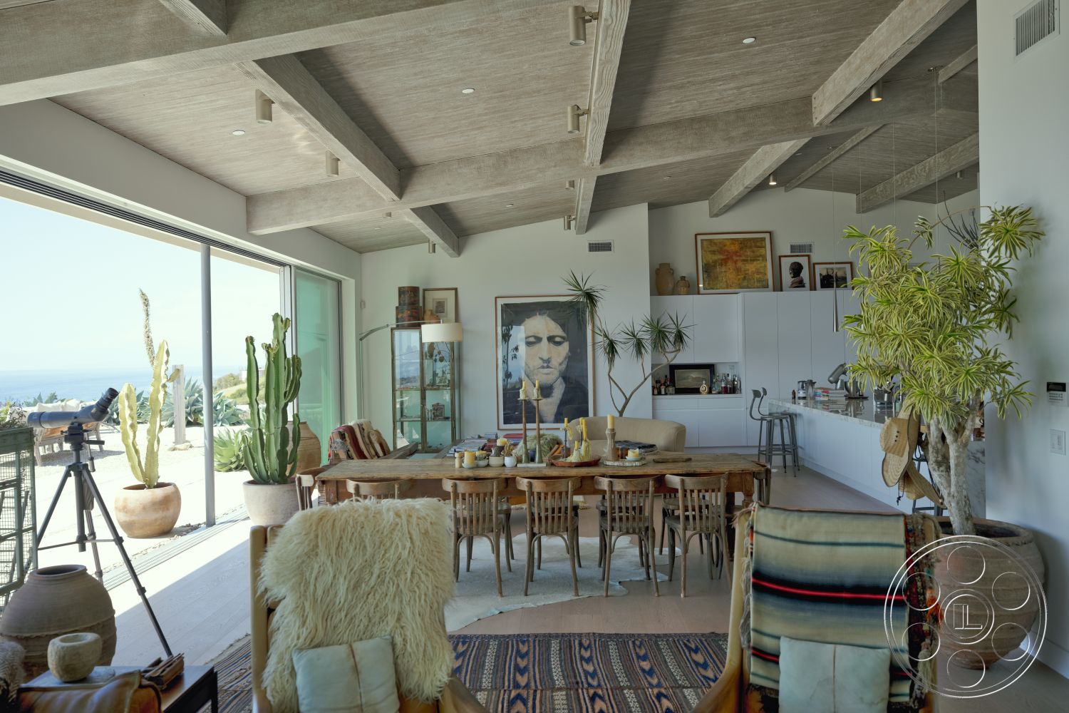 Modern 523 - neutral color palette, contemporary artwork, textured area rug, potted plants, modern pendant lighting, wood dining table, sliding glass doors, floor-to-ceiling windows, ceramic planters, exposed concrete ceiling, natural light flooding, stainless steel kitchen appliances, marble kitchen countertop, open-concept dining area, wood beam ceiling, rustic wood dining chairs, woven accent chairs, white kitchen cabinets, wood bookshelf
