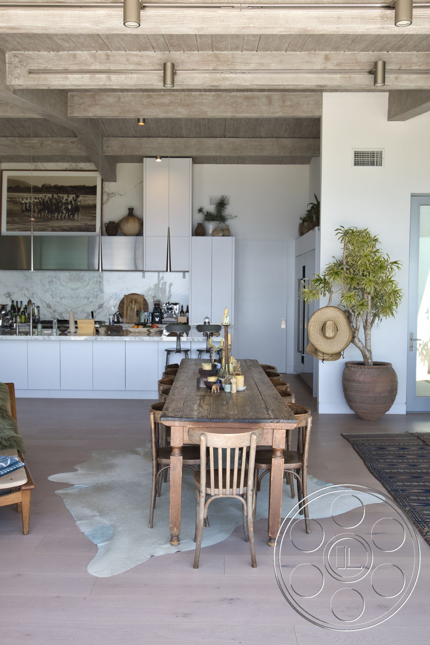 Modern 523 - contemporary pendant lighting, decorative indoor plant, wooden dining chairs, exposed wood ceiling beams, stainless steel kitchen appliances, open floor plan layout, minimalist kitchen cabinetry, light hardwood living room floors, rough-hewn wooden dining table, white marble kitchen backsplash, ceramic vase with greenery