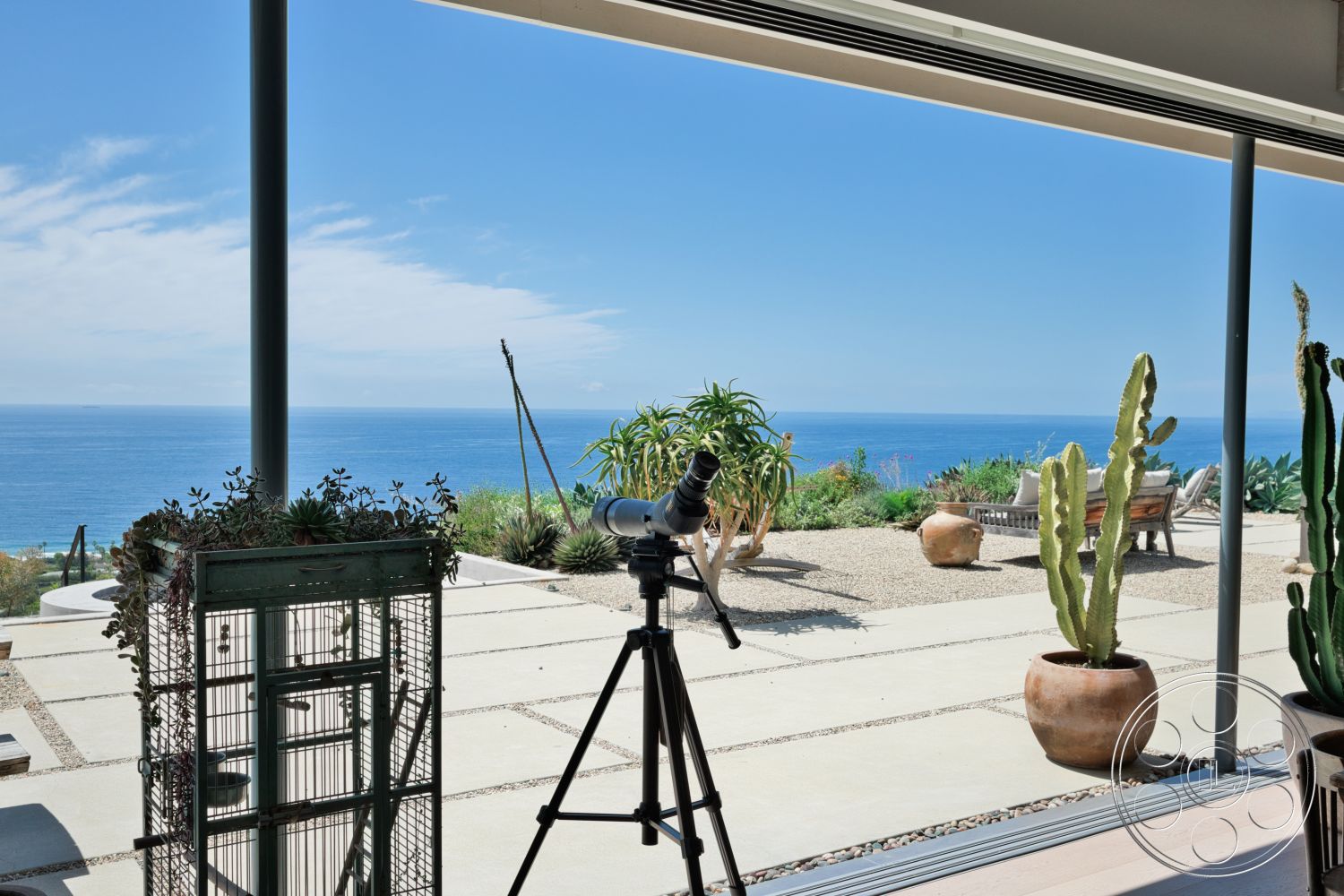 Modern 523 - exterior, gravel pathway, open-air living space, coastal setting, concrete patio flooring, contemporary home design, oceanfront view, floor-to-ceiling glass doors, steel structural beams, potted cactus plants, minimalist outdoor seating area, succulent plant arrangements, desert-style landscape design, terracotta garden pots, modern metal telescope stand, large horizontal windows