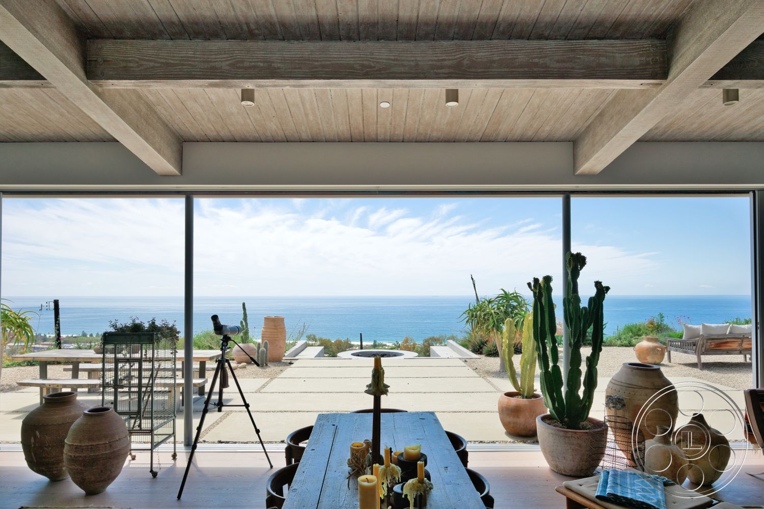 Modern 523 - minimalist design, glass sliding doors, modern aesthetic, outdoor lounge area, concrete patio flooring, wood beam ceiling, interior open space, slate stepping stones, exterior ocean view, planted ornamental grasses, rustic dining table, ceramic pottery accents