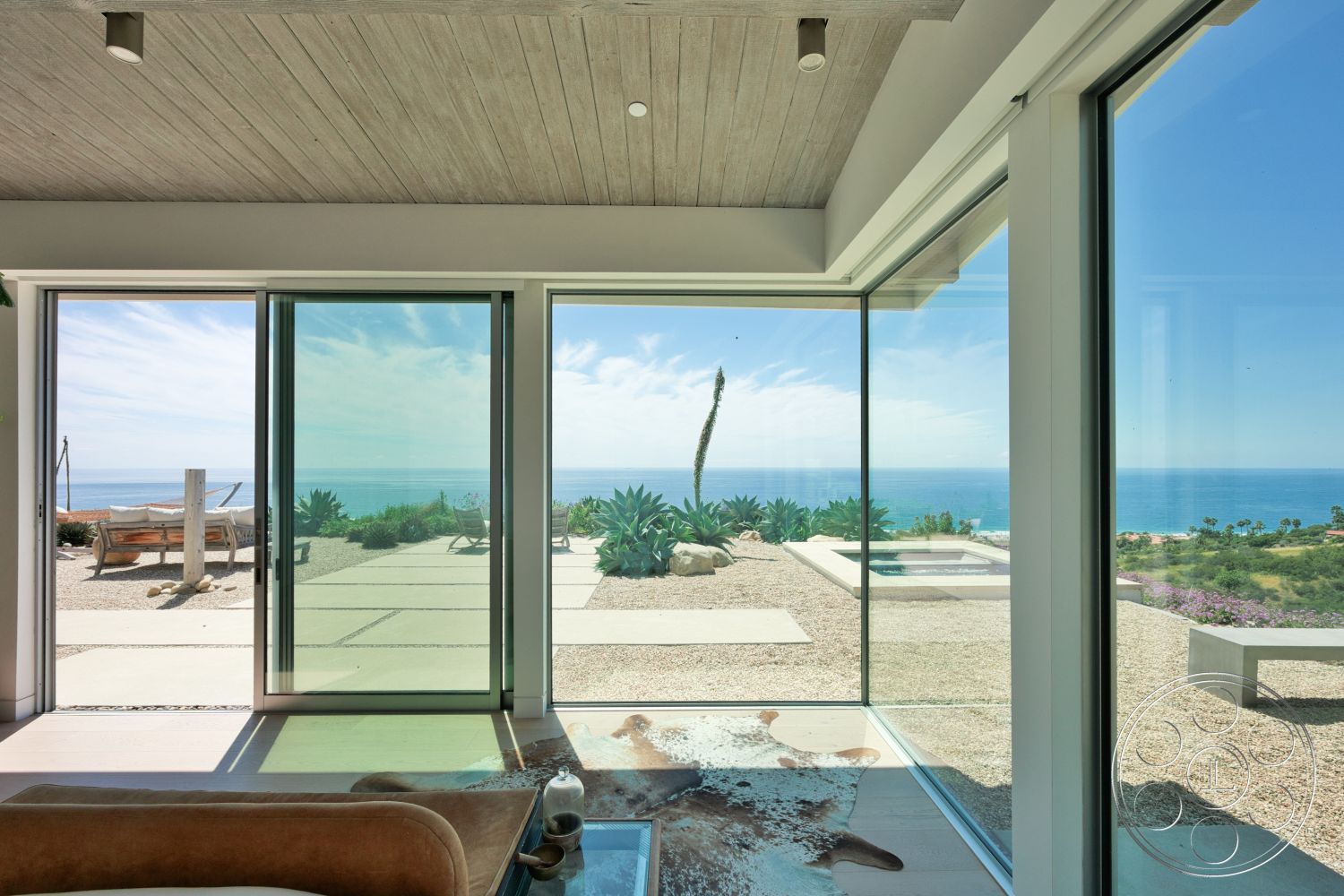Modern 523 - natural light, landscaped garden, minimalist design, glass sliding doors, spacious living area, outdoor lounge area, wood ceiling panels, modern architectural style, ocean view, concrete patio flooring