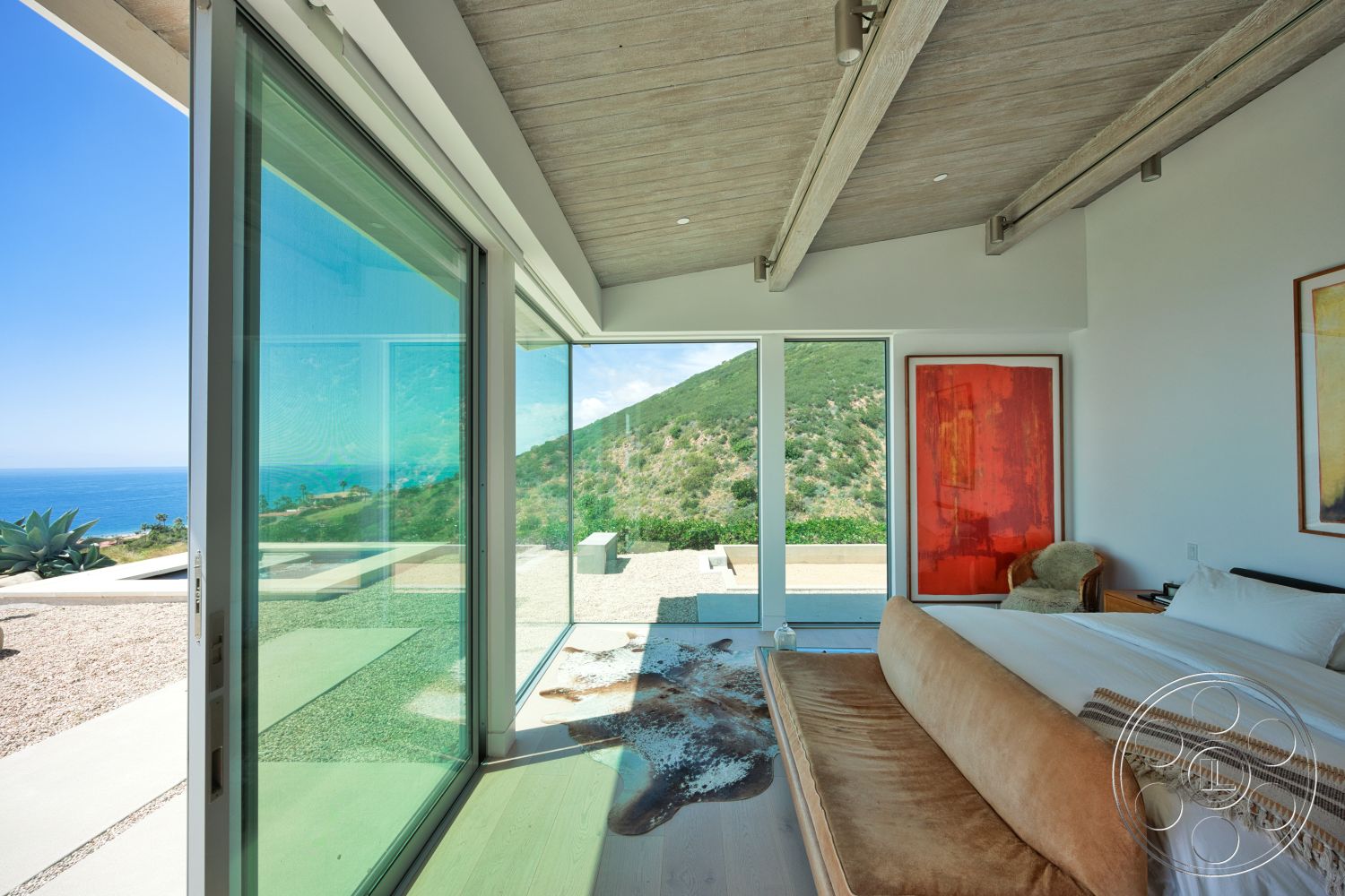 Modern 523 - light wood flooring, abstract wall art, open space layout, mountain view, modern bed frame, glass floor-to-ceiling windows, minimalist bedroom design, ocean view setting, vaulted wood ceiling with exposed beams, lounge area with velvet sofa