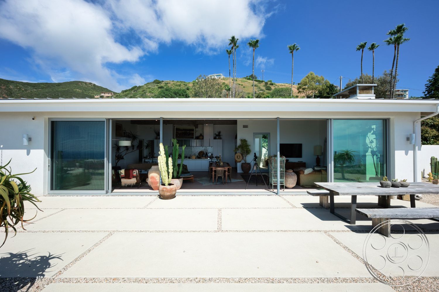 Modern 523 - exterior, minimalist design, open floor plan, natural landscaping, floor-to-ceiling windows, outdoor dining area, modern architectural style, concrete patio flooring, white painted walls, rectangle patio, mountain hillside location, cacti garden features