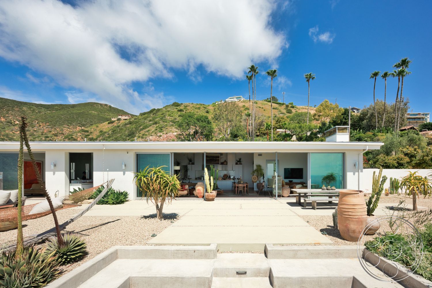 Modern 523 - exterior, flat roof, potted plants, outdoor dining area, concrete steps, contemporary design elements, modern architectural style, mountain view setting, concrete patio flooring, floor-to-ceiling sliding glass doors, decorative clay pots, wooden outdoor seating area, gravel garden, landscape with cacti, hammock installation