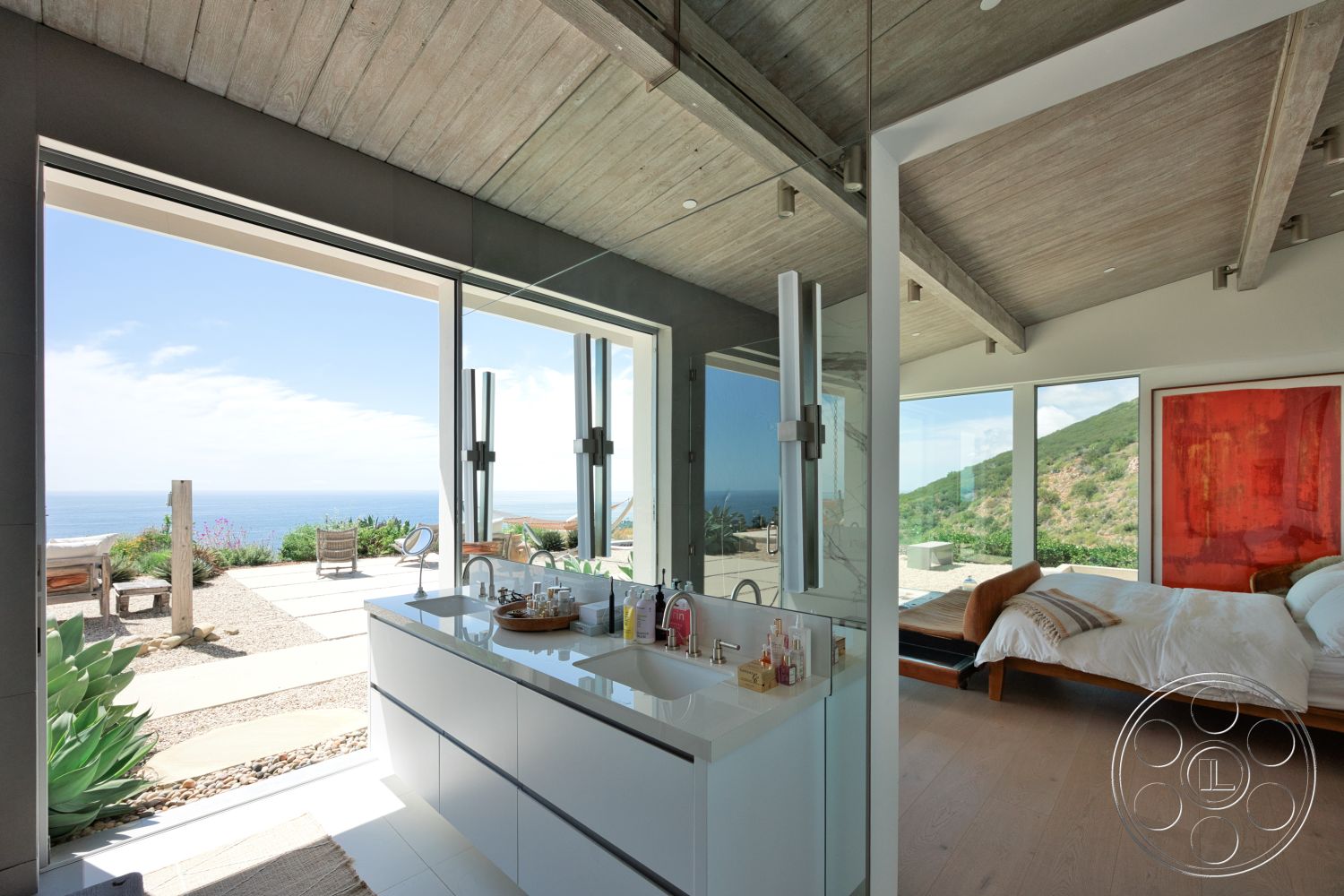 Modern 523 - glass shower enclosure, floor-to-ceiling windows, master bedroom, open-concept layout, exposed wood ceiling beams, white painted walls, concrete bathroom flooring, outdoor patio area, modern art piece on wall, light hardwood bedroom floors, modern double sink vanity, landscape view of ocean, natural stone pavers in patio area