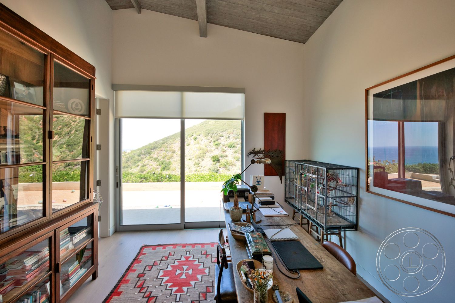 Modern 523 - natural light, hardwood flooring, textured wall, mountain view, glass display cabinet, large sliding glass doors, contemporary office, wood beam ceiling, geometric patterned area rug, rustic wooden desk, exposed architectural elements, artwork wall hanging