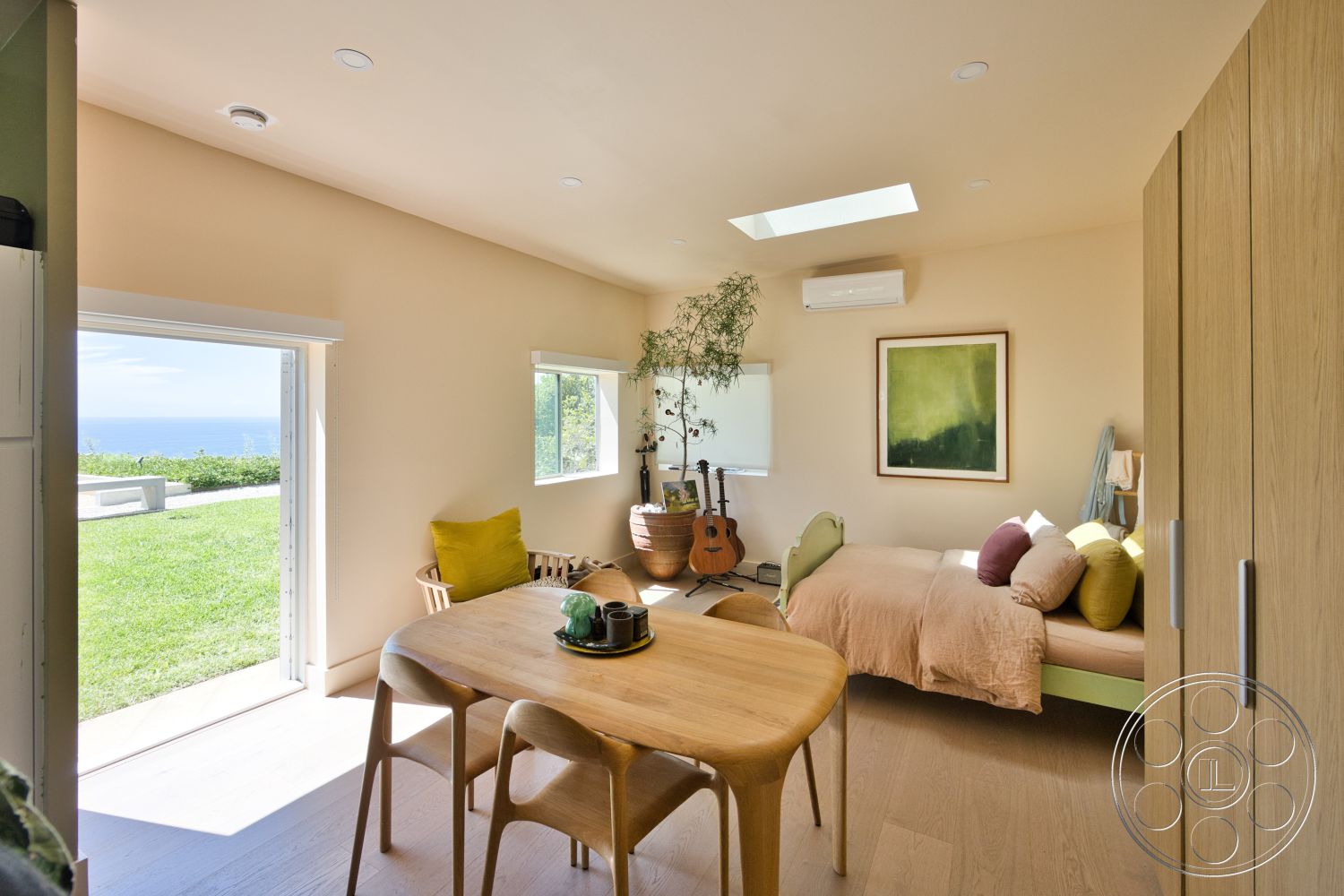 Modern 523 - natural lighting, indoor plants, open floor plan, light wood flooring, floor-to-ceiling windows, round dining table, framed wall art, ocean view, green accent pillows, plywood walls, wood dining chairs, skylight ceiling