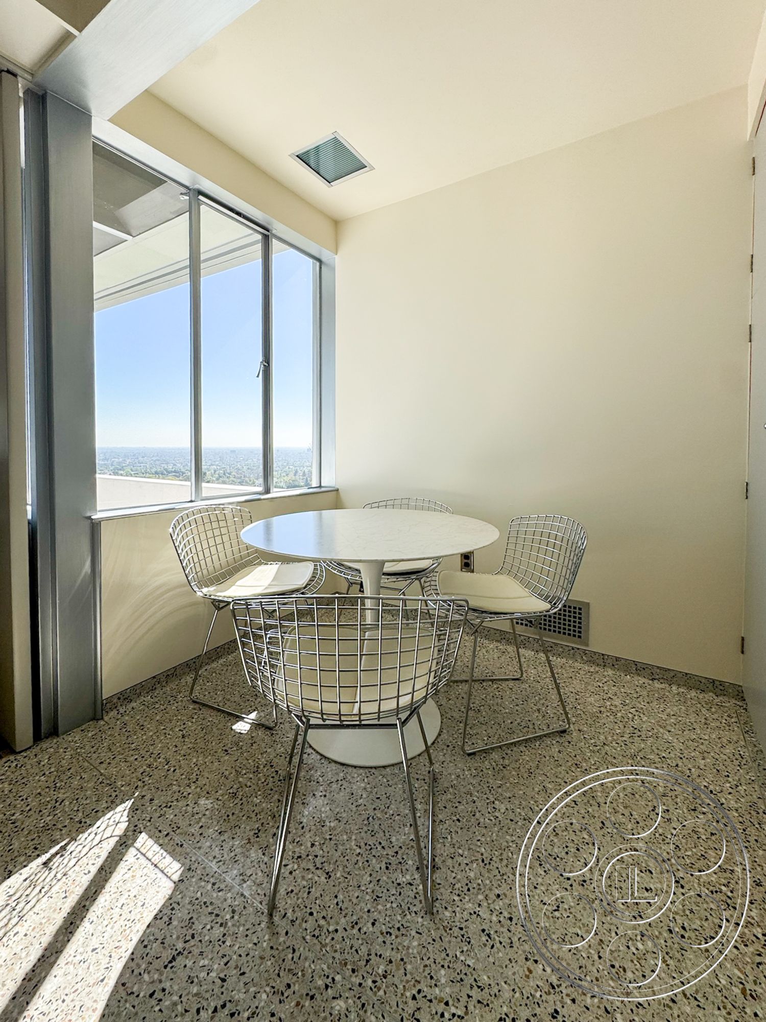 The Kun House - terrazzo flooring, contemporary furniture, bright natural light, floor-to-ceiling windows, neutral painted walls, modern table design, white round dining table, metal wire dining chairs