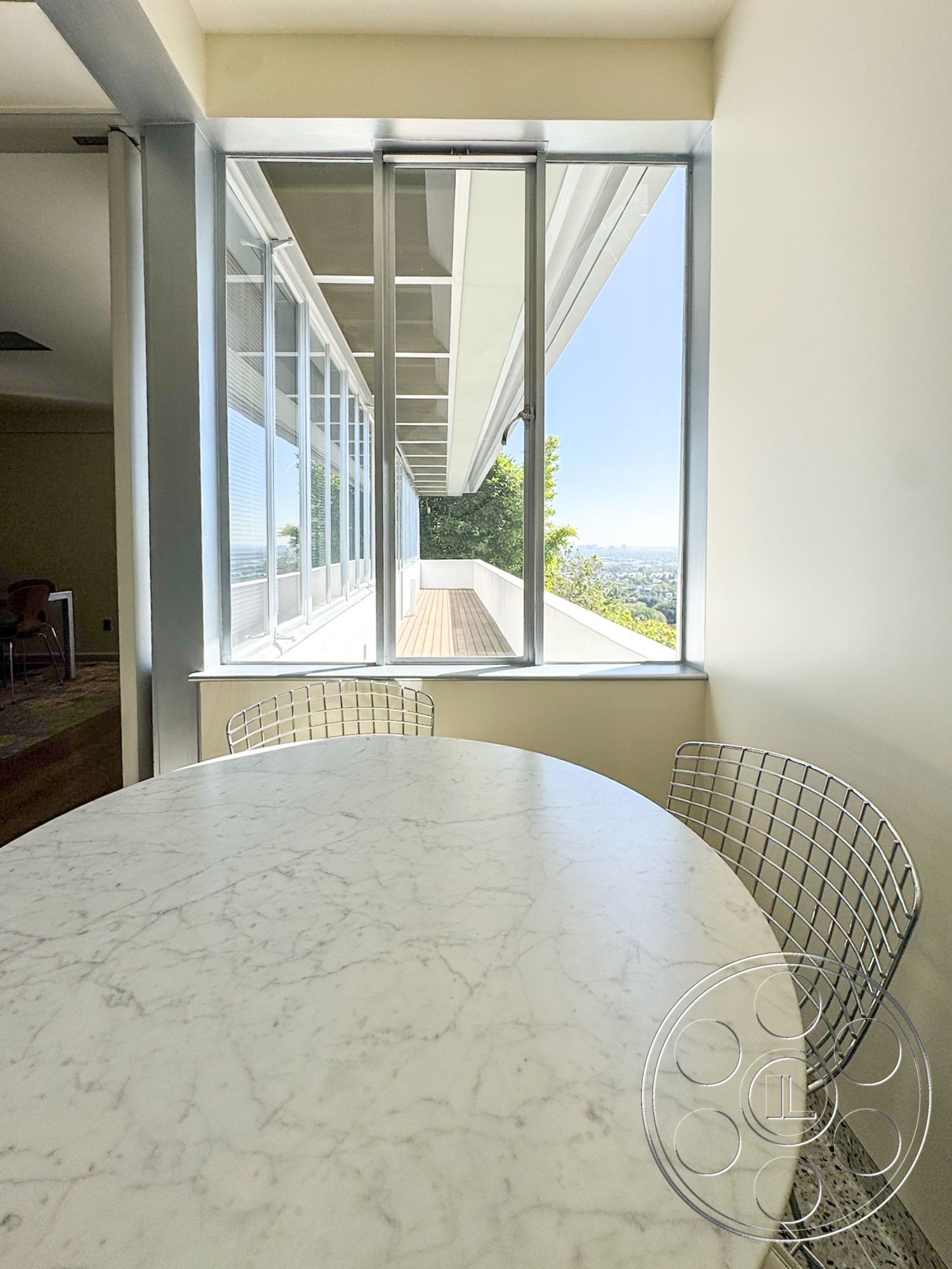 The Kun House - natural light, modern architecture, minimalist design, concrete flooring, floor-to-ceiling windows, marble dining table, cantilevered roof, metal wire dining chairs, view of outdoor deck