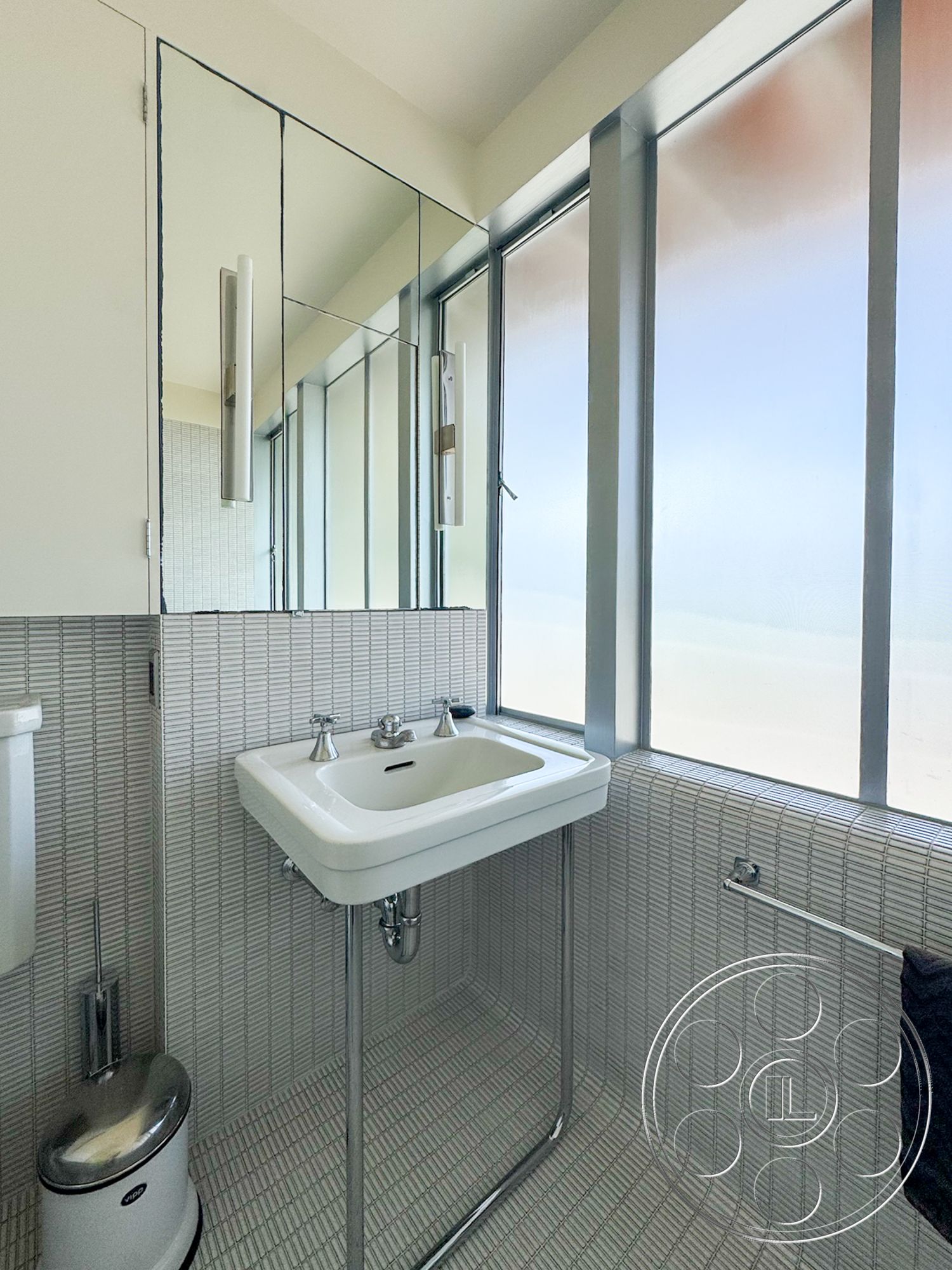 The Kun House - minimalist design, floor-to-ceiling windows, tile bathroom walls, mosaic tile flooring, wall-mounted towel bar, modern sink with chrome faucet, stainless steel trash can, framed bathroom mirror