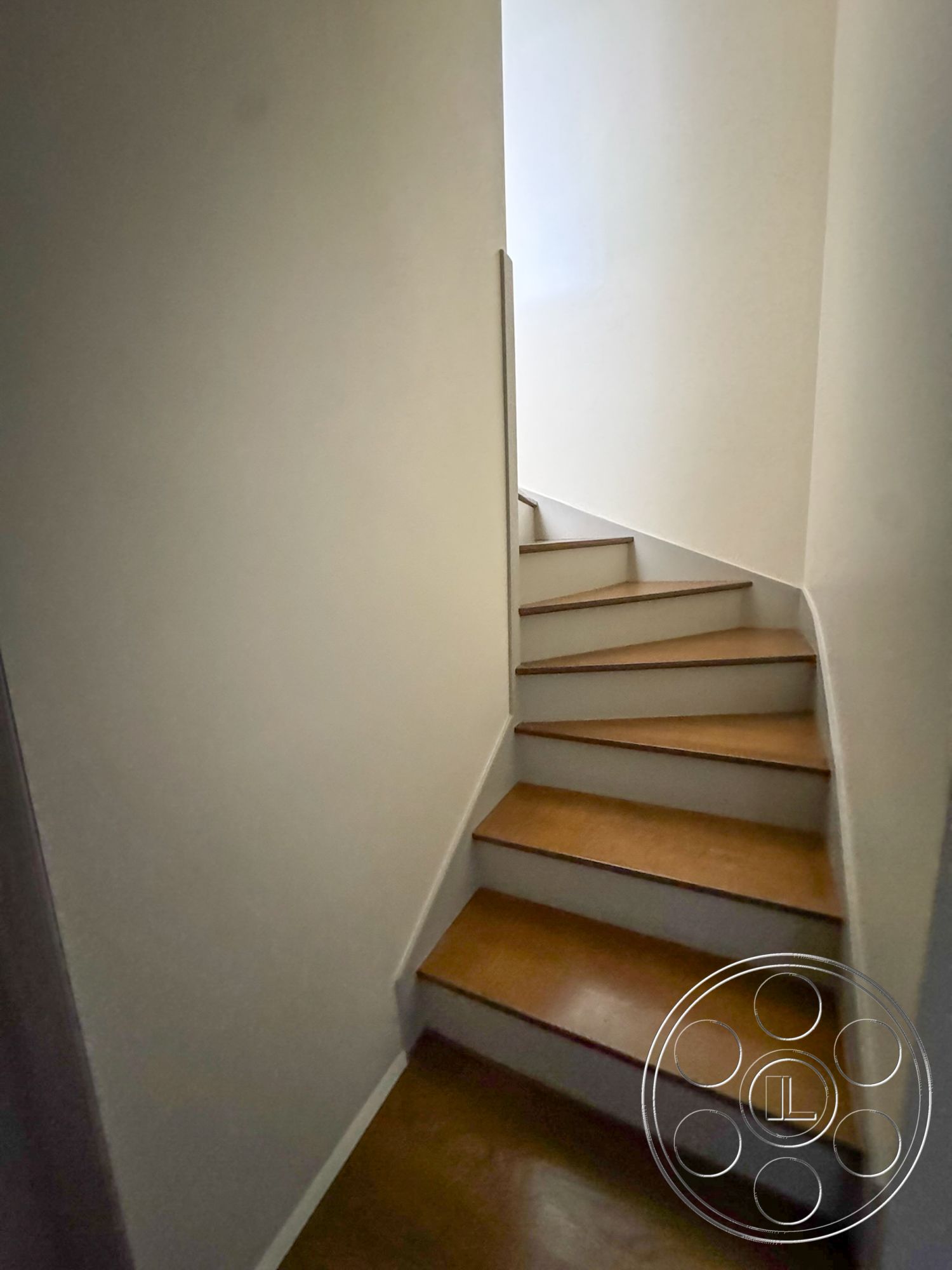 The Kun House - white painted walls, straight staircase, hardwood staircase steps, light-colored wall trim, natural light from top of stairs