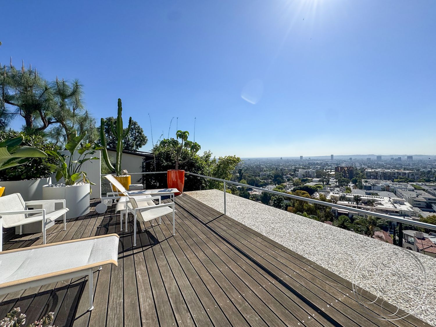The Kun House - exterior, glass railing, modern outdoor furniture, potted greenery, desert landscaping, panoramic city view, wood deck flooring, concrete patio edge, sunny hillside setting