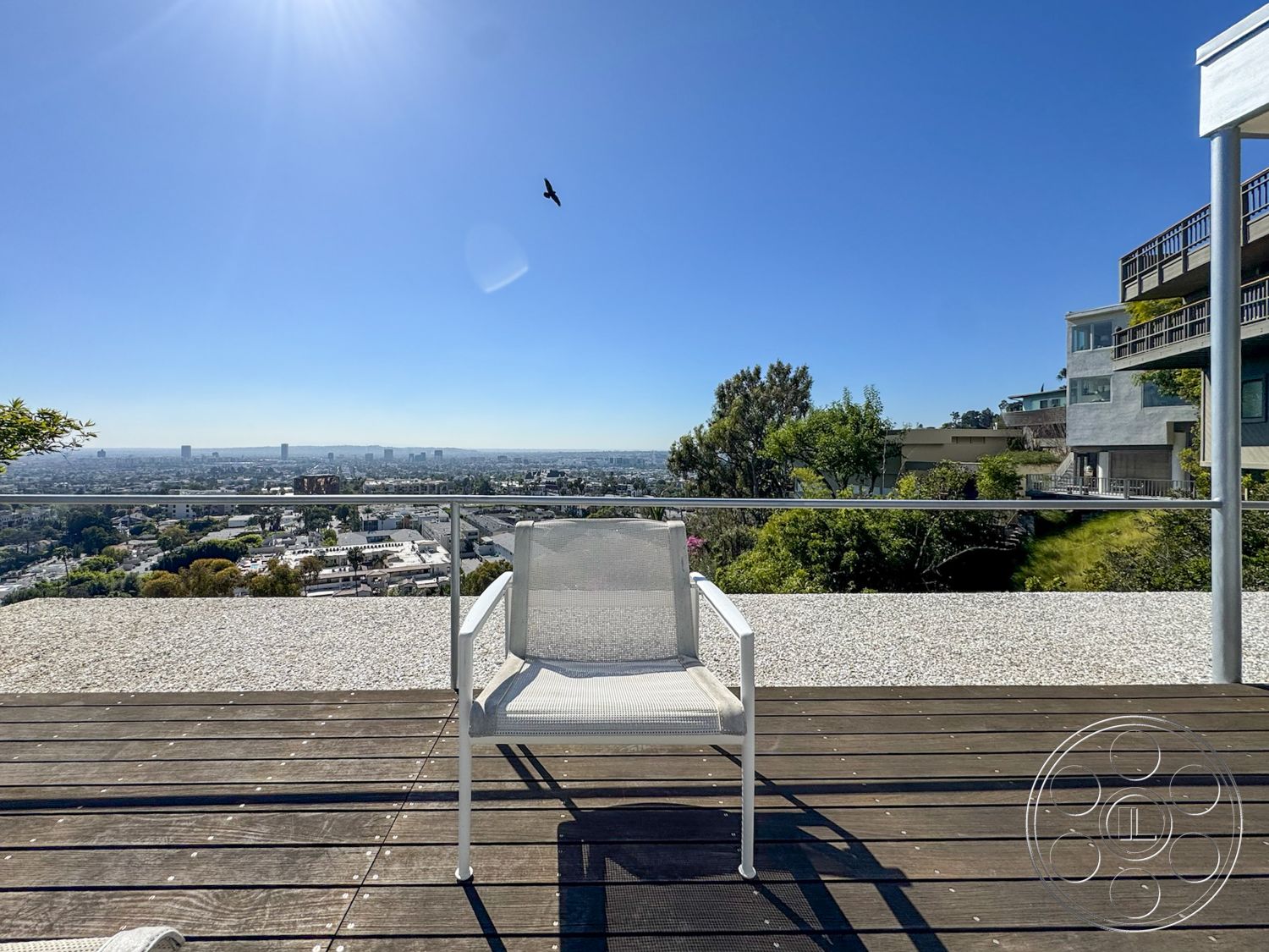 The Kun House - exterior, metal railing, modern architectural style, city skyline view, clear blue sky, wooden deck flooring, concrete patio border, landscaped hillside garden, single modern chair, terraced planting