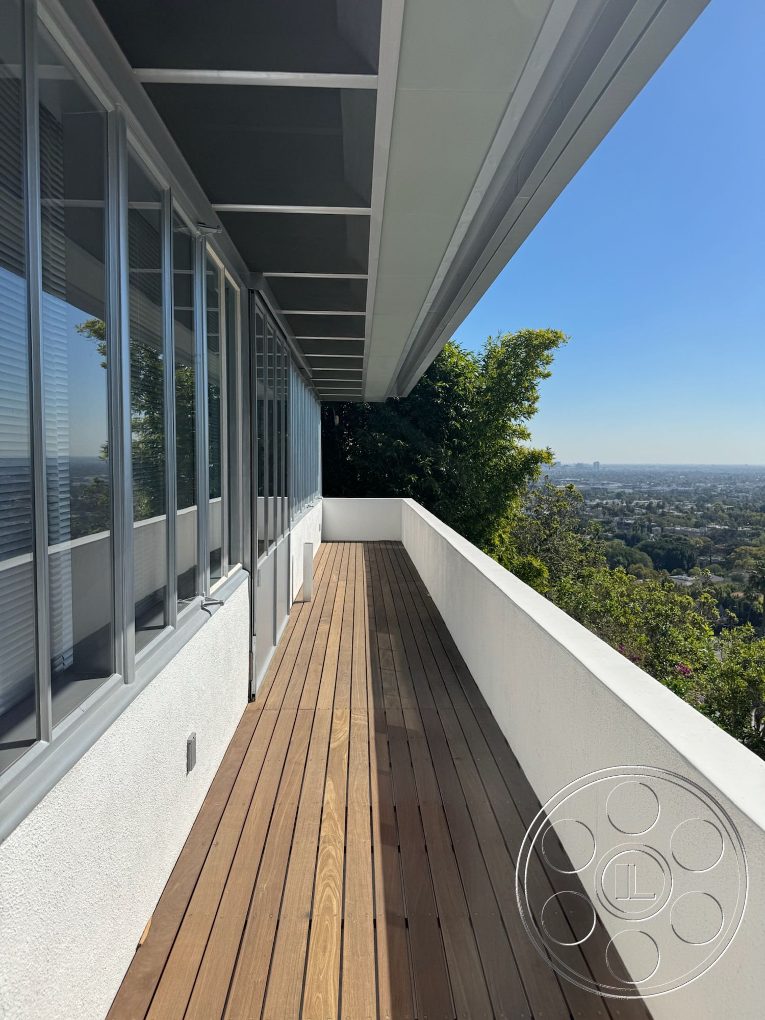 The Kun House - large windows, exterior, minimalist design elements, glass sliding doors, wood decking, modern architectural style, scenic hillside view, flat roof with overhang, concrete railing