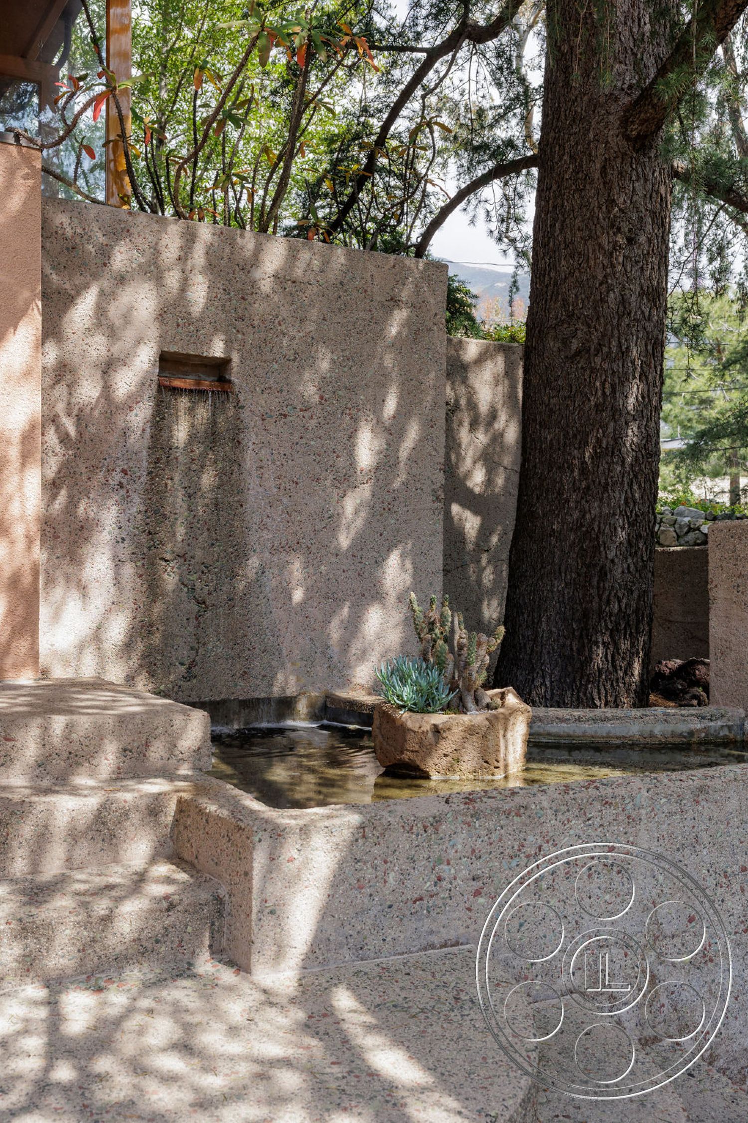Mid-Century Exotic - surrounding trees, concrete steps, outdoor setting, exposed aggregate concrete walls, natural stone planter, rectangular concrete water feature, interior elements visible, rough texture wall treatments