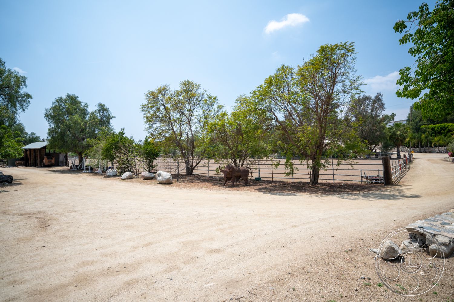 Ranch 6 - exterior, natural landscaping, gravel path, metal roof, deciduous trees, dirt driveway, wooden fencing, wooden barn structure, open pasture area, homeyard setting