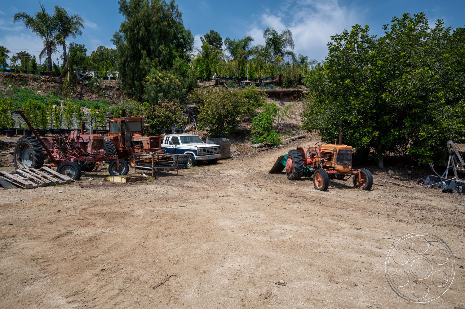 Ranch 6 - exterior, lush greenery, palms, dirt ground, hillside location, agricultural setting, wooden pallets, white pickup truck, rusted farm equipment, vintage tractor, red tractor