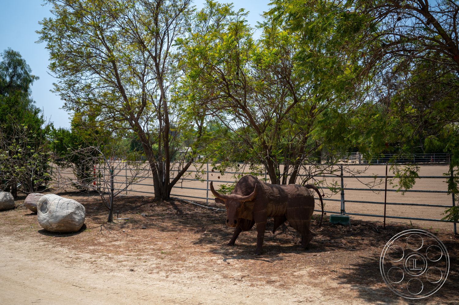 Ranch 6 - natural landscaping, rock garden, deciduous trees, dirt pathway, open field, outdoor environment, fence enclosure, dry dirt ground, metal sculpture