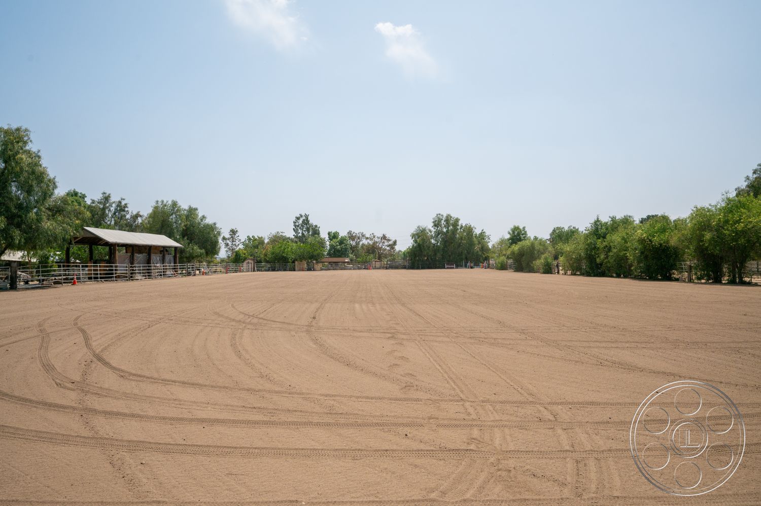 Ranch 6 - exterior, fenced area, clear blue sky, landscape trees, open pasture, sand riding arena, wooden shelter structure, dirt surface, outdoor equestrian facility