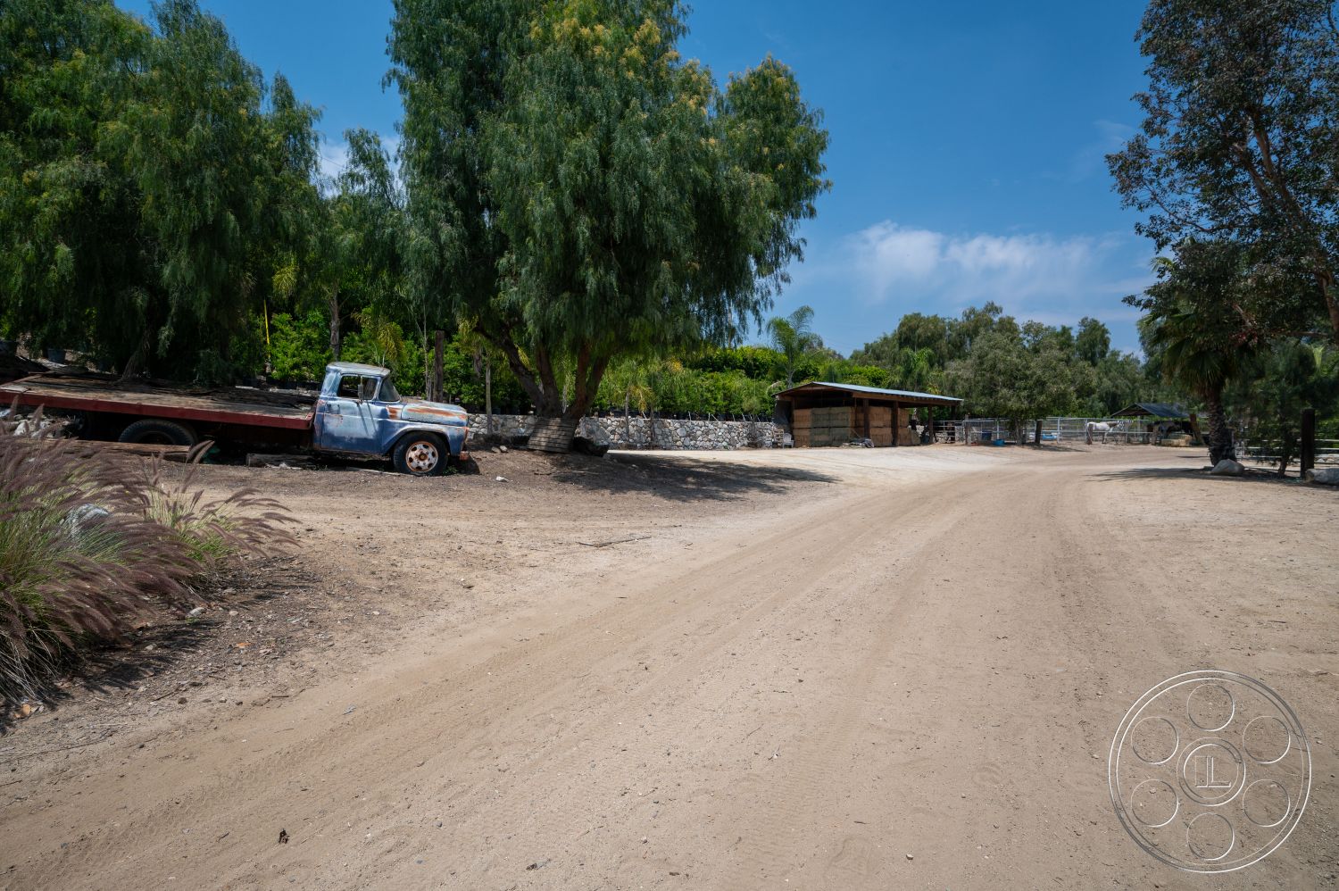 Ranch 6 - exterior, stone wall, surrounding trees, natural landscape, farmhouse style, dirt road, weathered wooden structures, outdoor rural setting, rustic wooden barn, vintage pick-up truck, open farm field