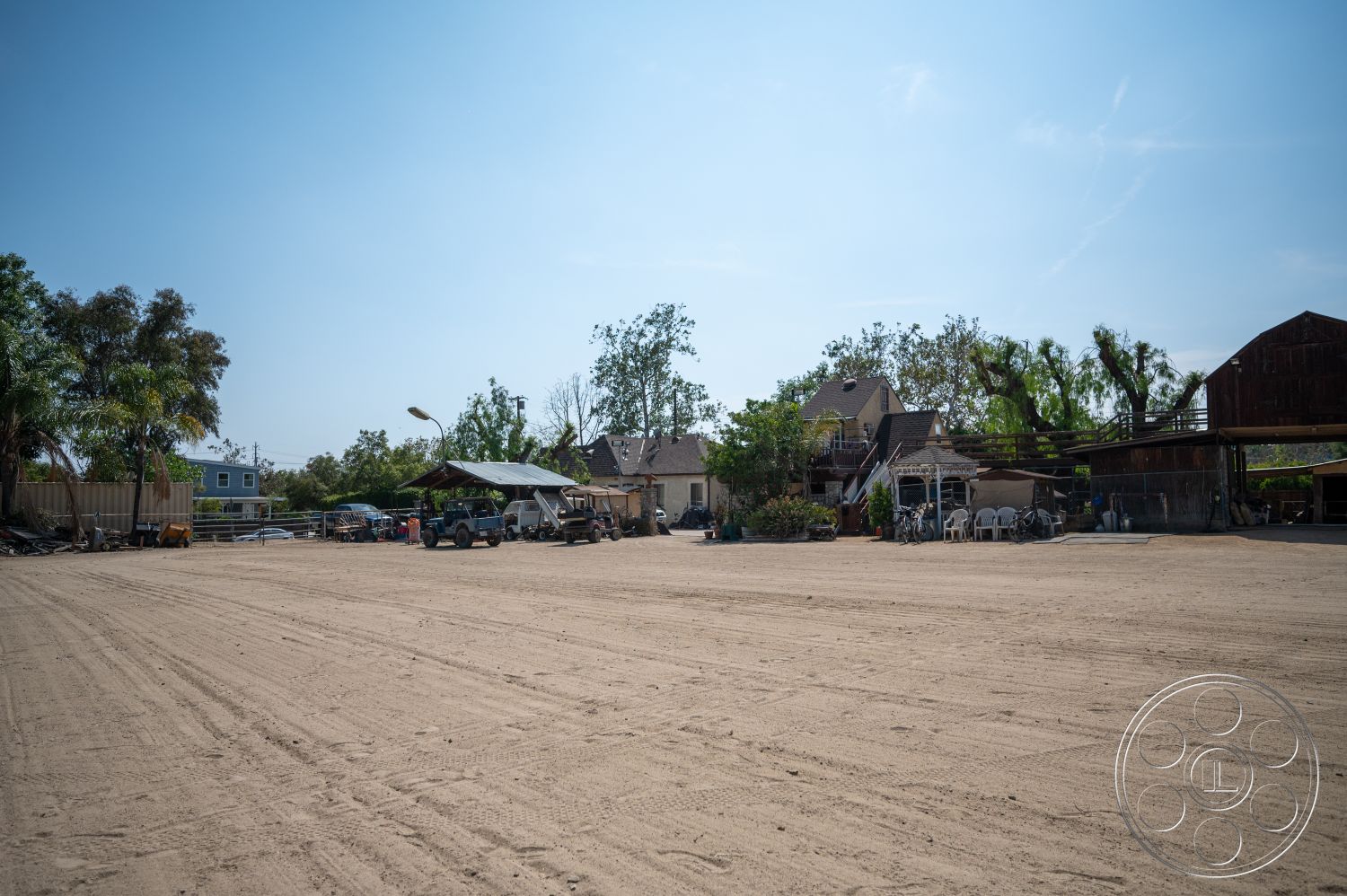 Ranch 6 - exterior, landscaped garden, open space layout, surrounding trees, wooden structure, metal roof, outdoor parking area, dirt ground surface, residential buildings